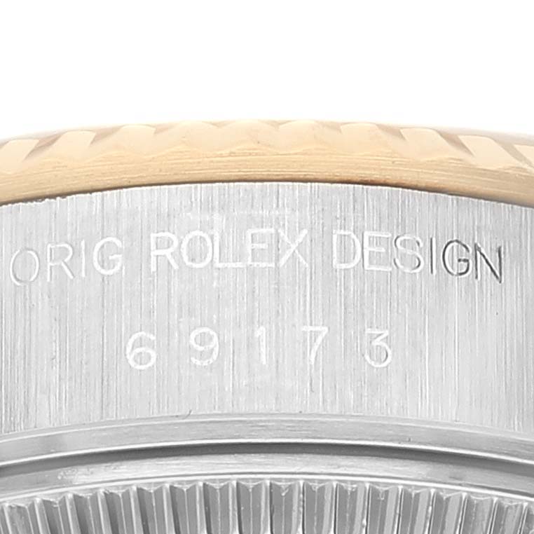 This close-up image displays part of the casing, with engraving details, of a Rolex Datejust 69173 Women's Steel and Gold (two tone) Champagne Dial 69173 Women's Steel and Gold (two tone) Champagne Dial model watch.