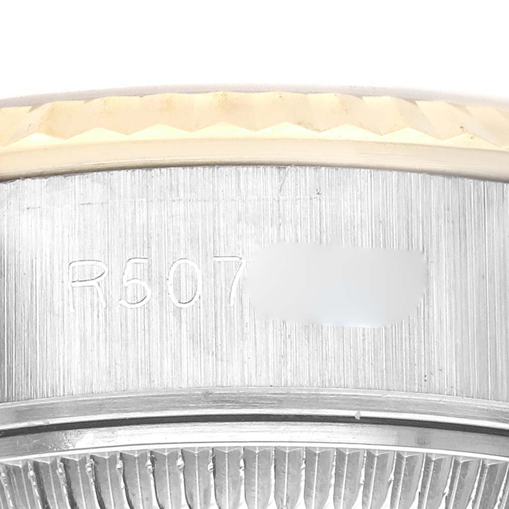 This is a close-up image of the outer rim of a Rolex Datejust 69173 Women's Steel and Gold (two tone) Champagne Dial 69173 Women's Steel and Gold (two tone) Champagne Dial watch, showing part of its serial number and the fluted bezel.