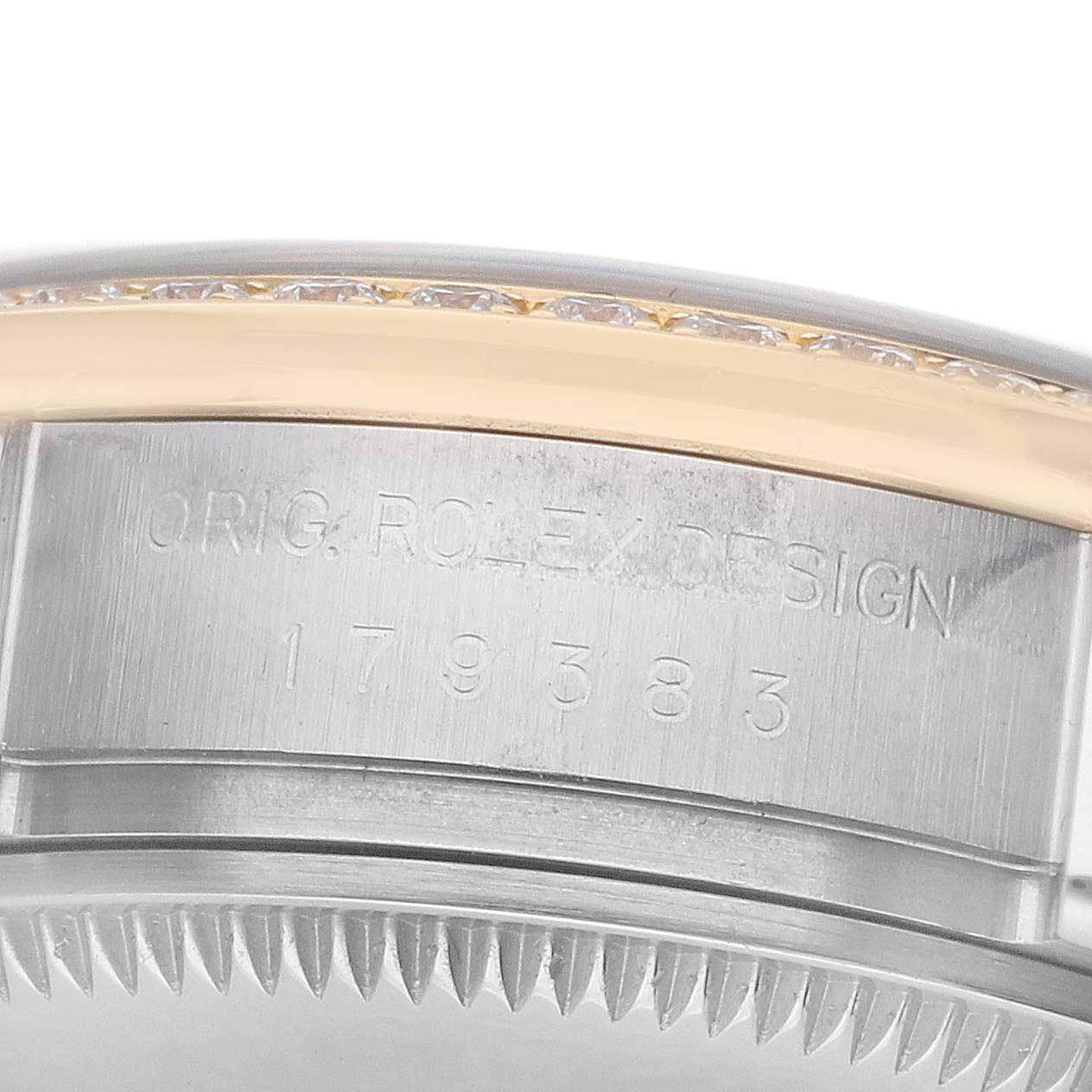 The image shows a close-up of the side and edge of the case for a Rolex Datejust 179383 Women's Steel and Gold (two tone) Mother of Pearl Dial, highlighting a part of the bezel and serial engraving.