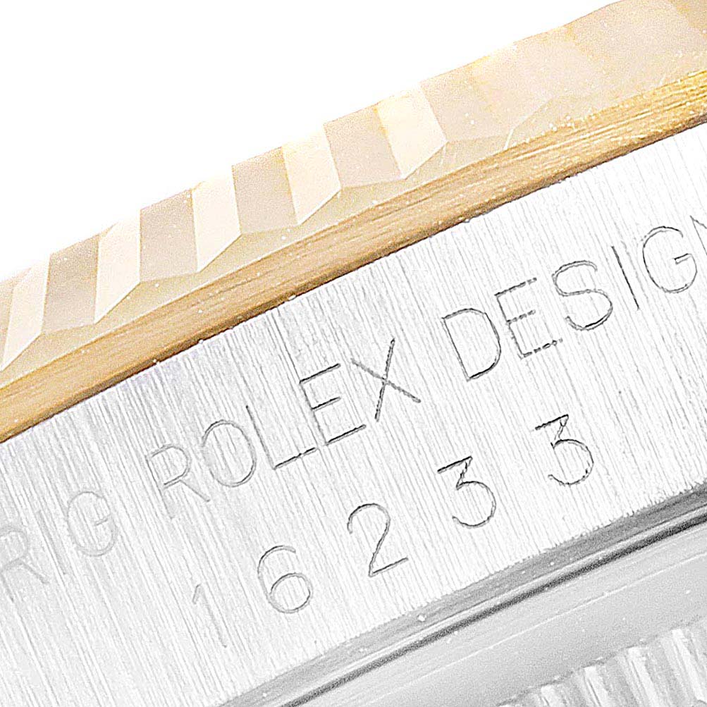 The image shows a close-up of the engraved bezel and serial number on a Rolex Datejust 16233 Men's Steel and Gold (two tone) White Dial 16233 Men's Steel and Gold (two tone) White Dial watch.