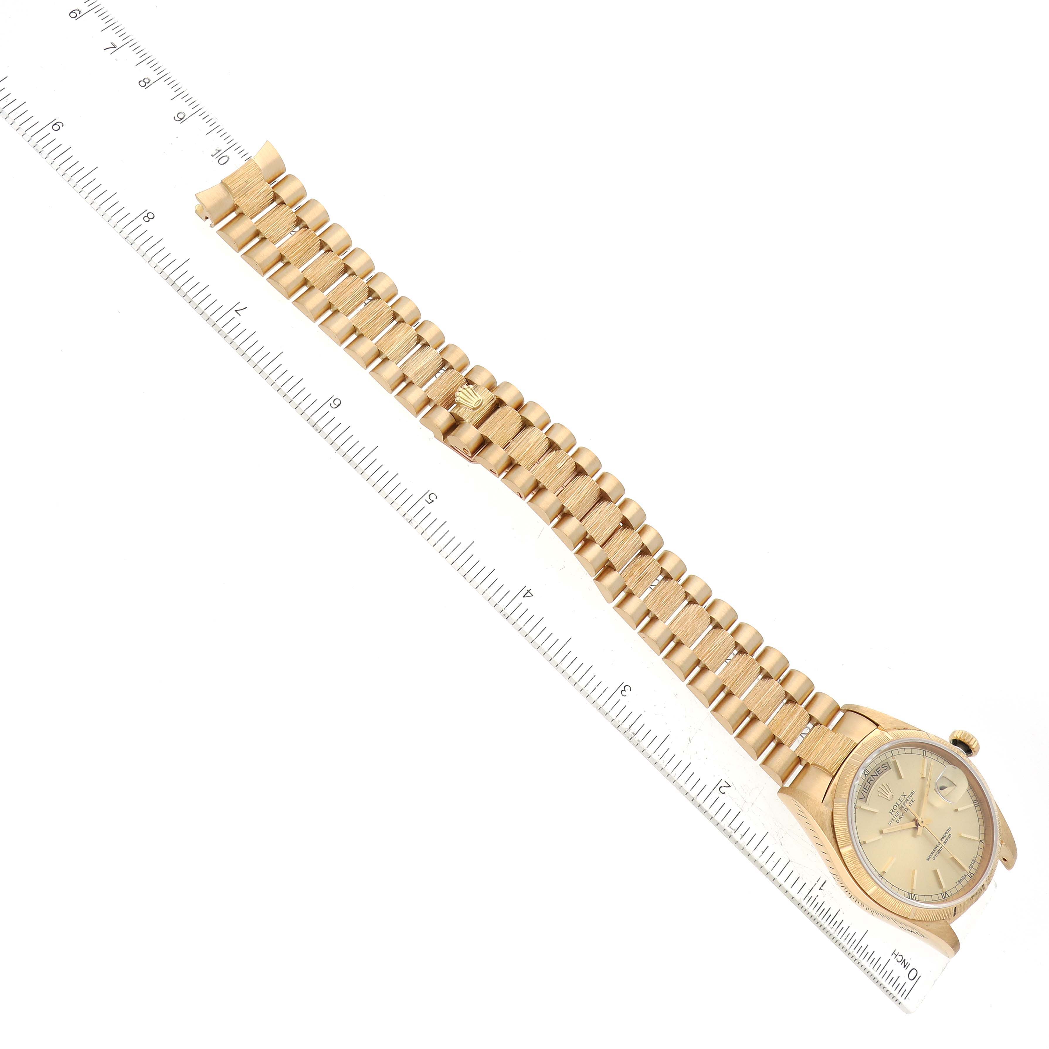 The image shows a top view of a Rolex President 18248 Men
s Yellow Gold Champagne Dial 18248 Men
s Yellow Gold Champagne Dial model watch, highlighting its gold bracelet and dial next to a ruler.