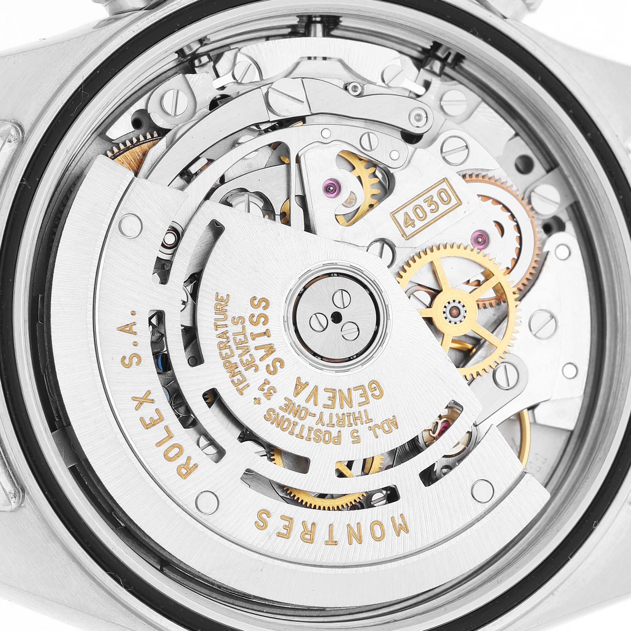 The image shows the Rolex Daytona 16520 Men's Stainless Steel Black Dial watch movement from a close-up angle, displaying gears and intricate mechanical details.