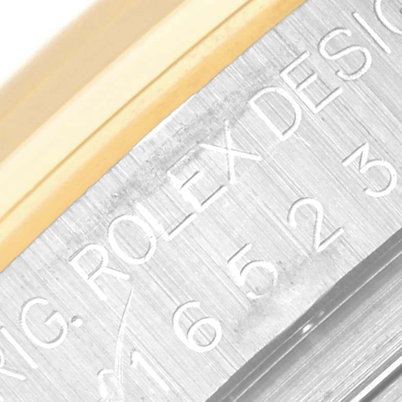 This close-up image of a Rolex Daytona 16523 Men's Steel and Gold (two tone) Champagne Dial 16523 Men's Steel and Gold (two tone) Champagne Dial watch shows the engraved design information and part of the bezel.