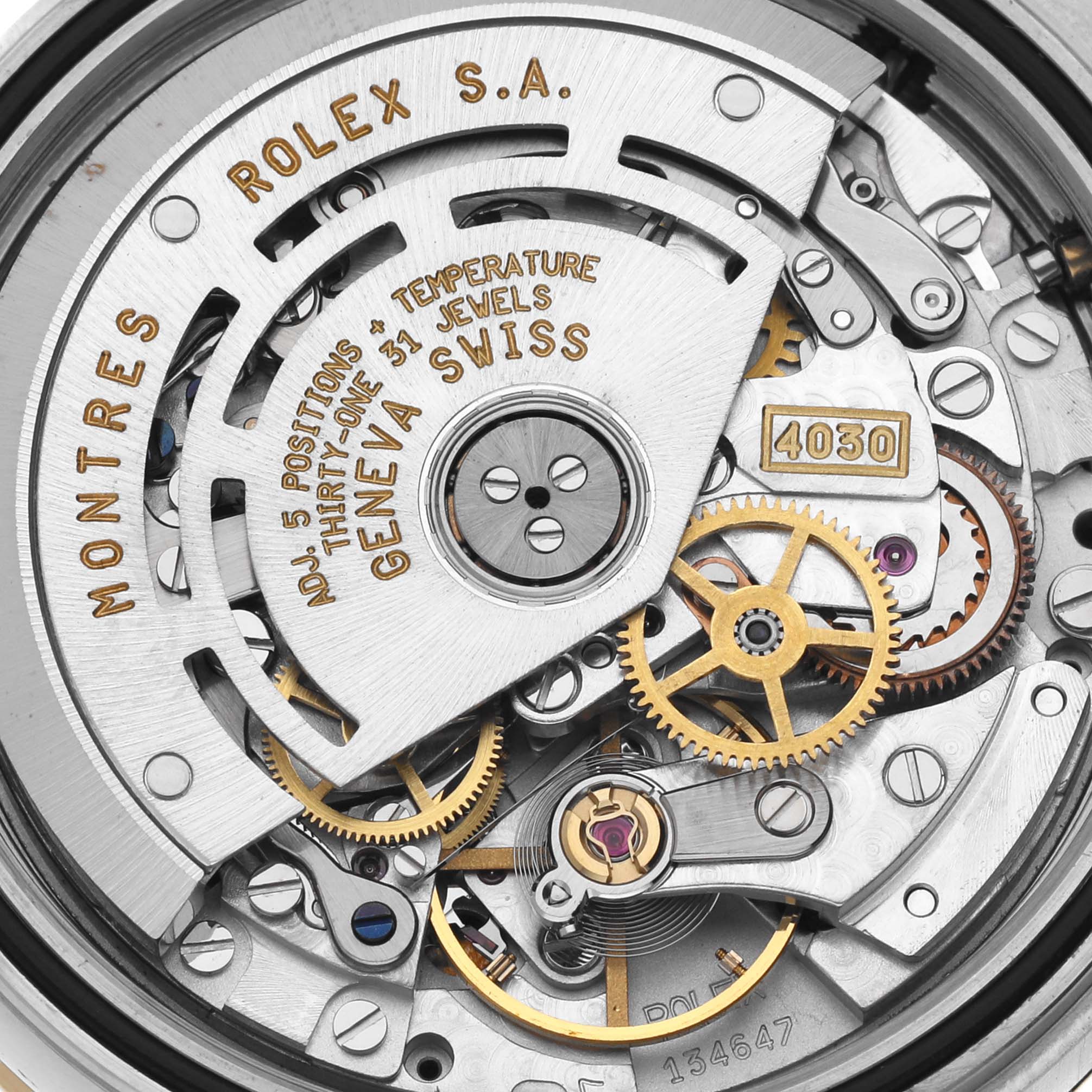 The image shows the intricate inner mechanical movement of a Rolex Daytona 16523 Men's Steel and Gold (two tone) Champagne Dial 16523 Men's Steel and Gold (two tone) Champagne Dial watch, highlighting gears and text engravings.