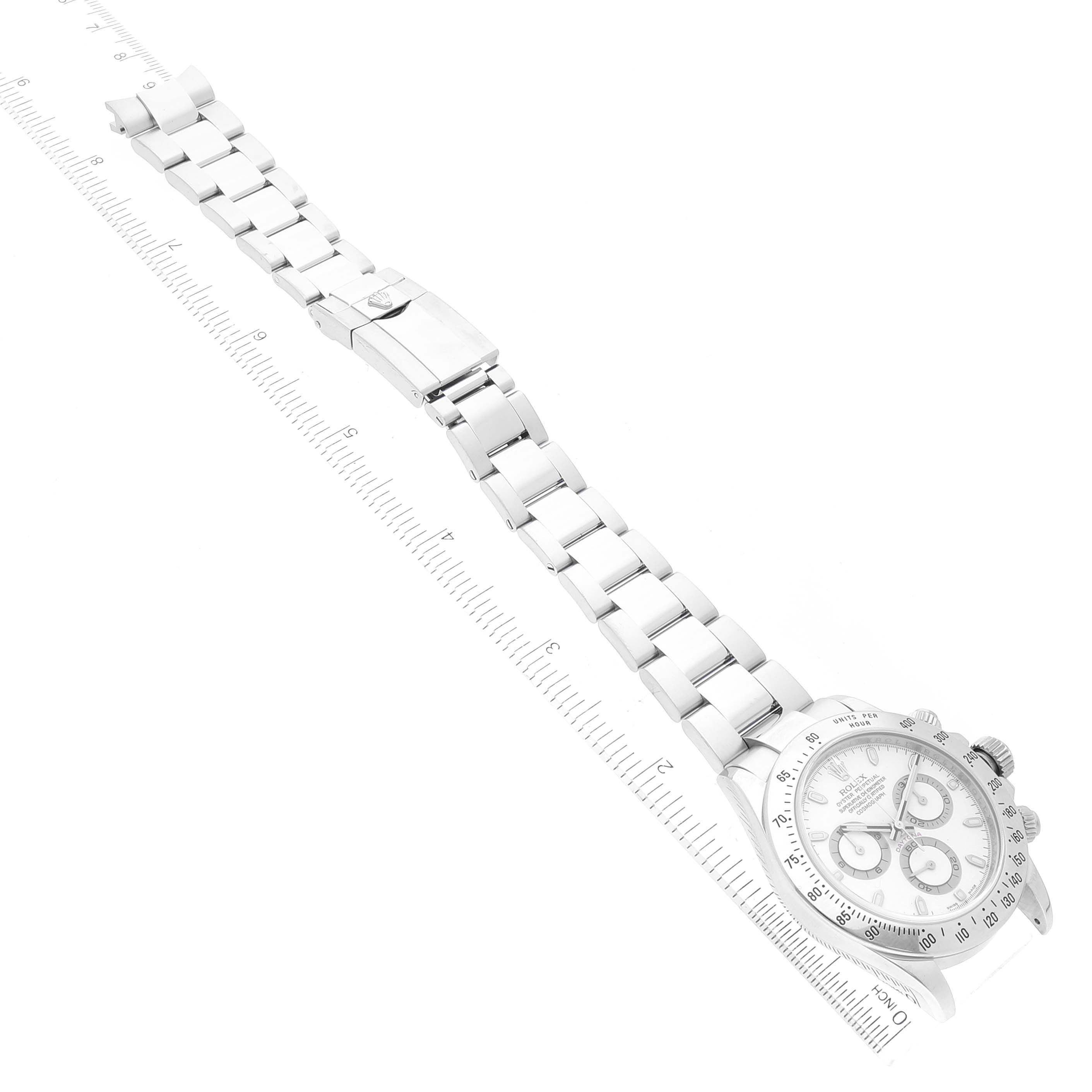 This image shows the Rolex Daytona 116520 Men's Stainless Steel White Dial 116520 Men's Stainless Steel White Dial watch laid flat, highlighting the face, bezel, bracelet, and clasp, with a ruler for scale.