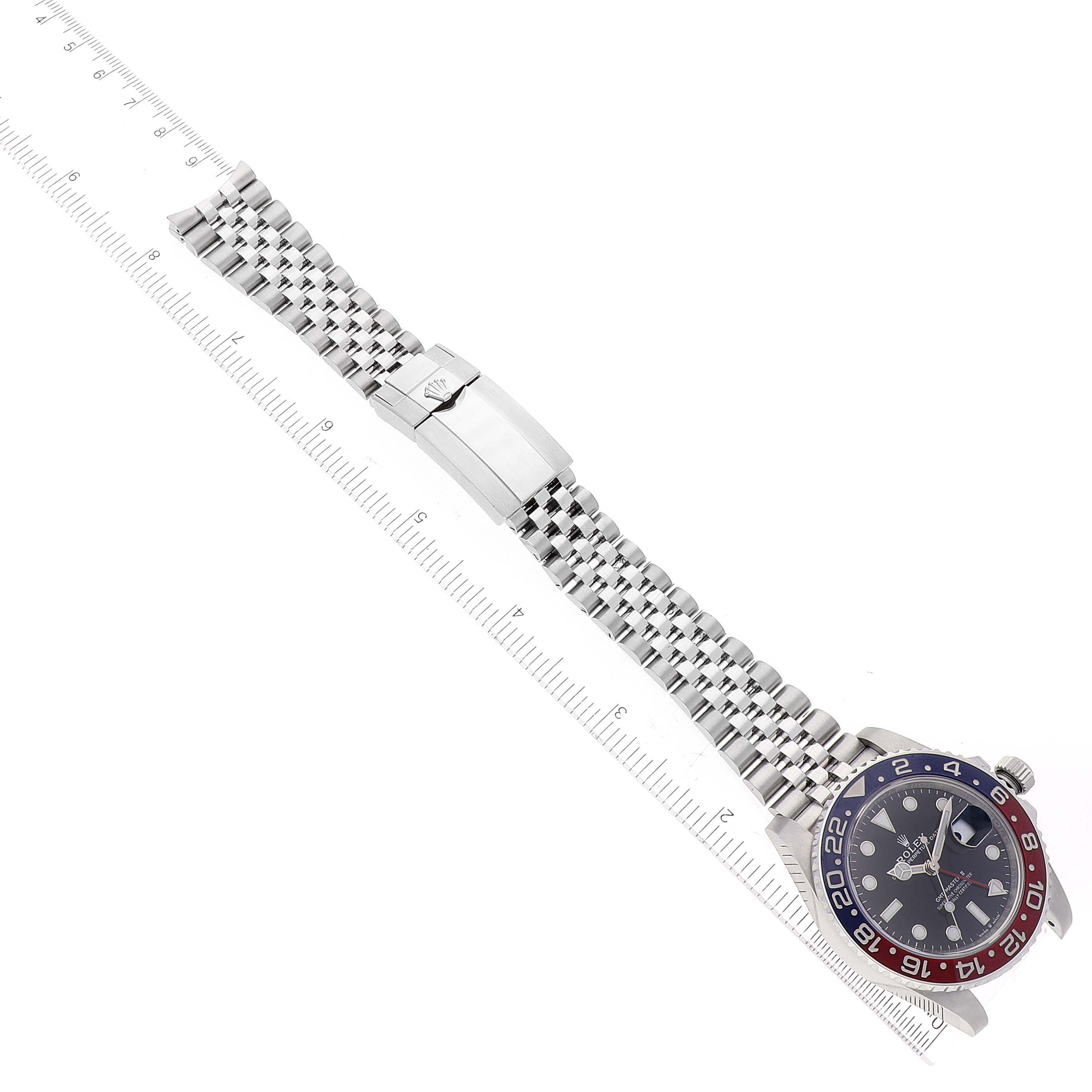 The image shows a top view of a Rolex GMT-Master 126710 Men's Stainless Steel Black Dial 126710 Men's Stainless Steel Black Dial watch with its dial, bezel, and bracelet laid flat next to a ruler.