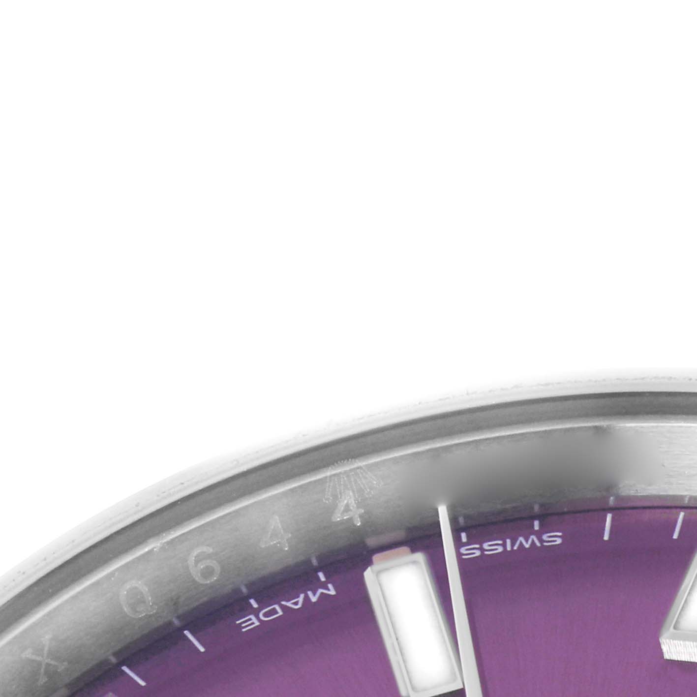 The image shows a close-up of the dial's lower right section of a Rolex Oyster Perpetual 114200 Men's Stainless Steel Red Dial, highlighting the bezel and hour markers.