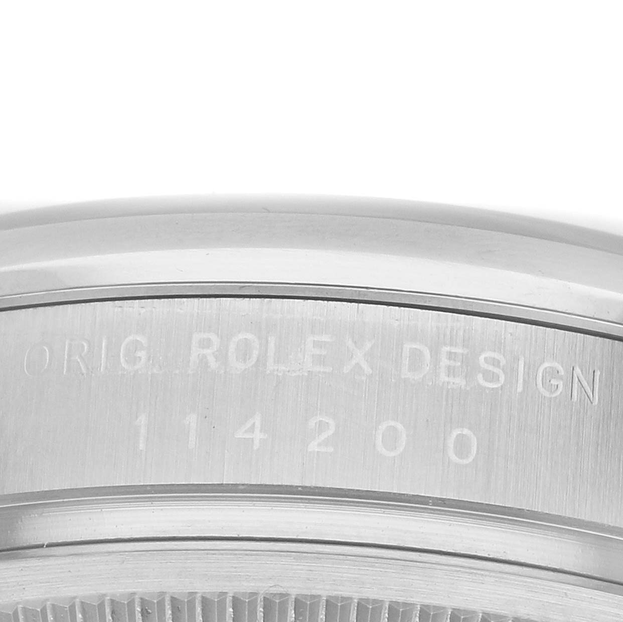 The image shows the side of a Rolex Oyster Perpetual 114200 Men's Stainless Steel Red Dial watch, highlighting the engraved model number.