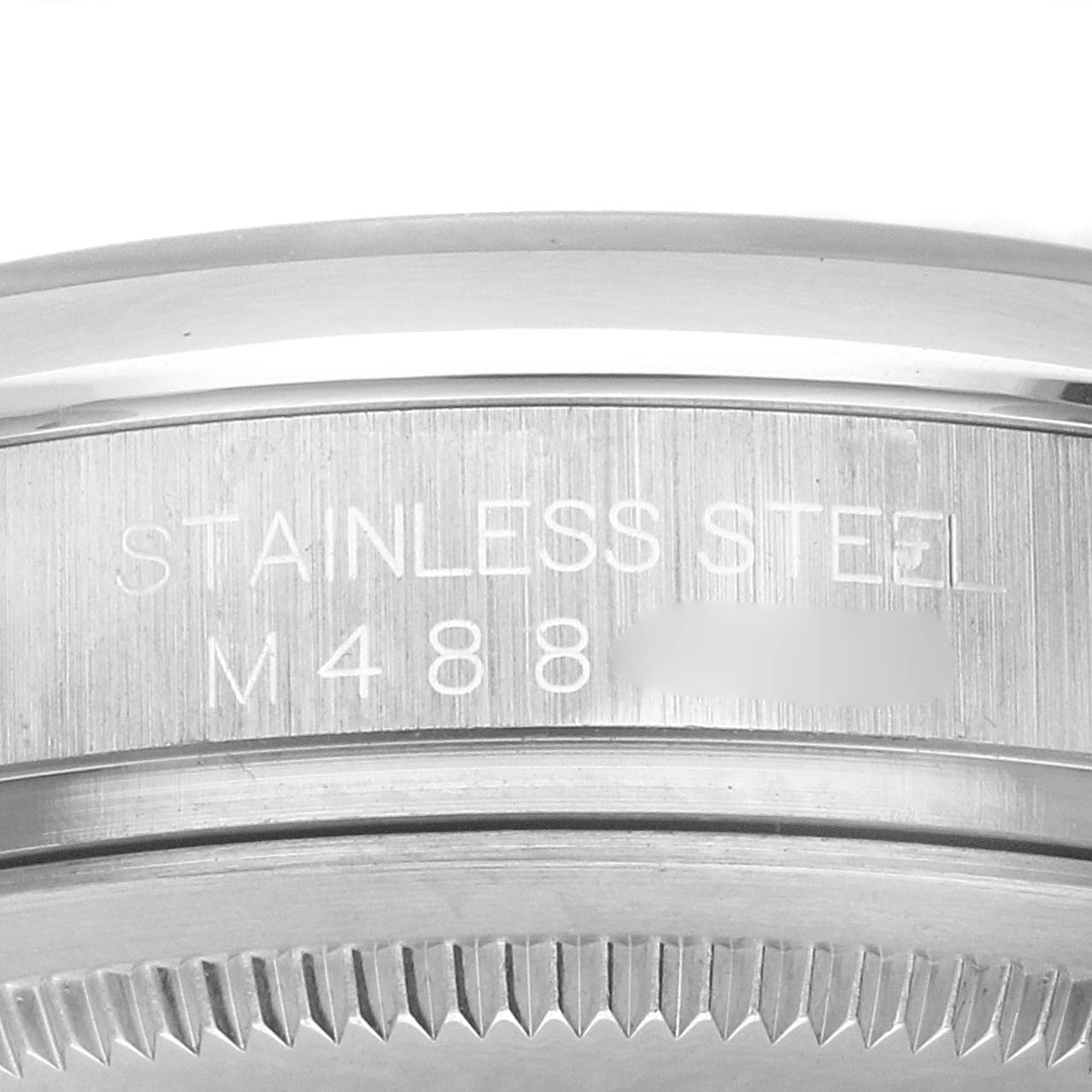 The image shows a close-up of the stainless steel casing and engravings on a Rolex Oyster Perpetual 116000 Men's Stainless Steel Black Dial watch, focusing on the side.