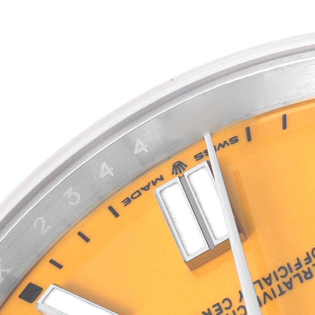 This image shows a close-up of the dial
s upper portion on a Rolex Oyster Perpetual 124300 Men
s Stainless Steel Yellow Dial 124300 Men
s Stainless Steel Yellow Dial, highlighting the bezel, markers, and "Swiss Made" text.