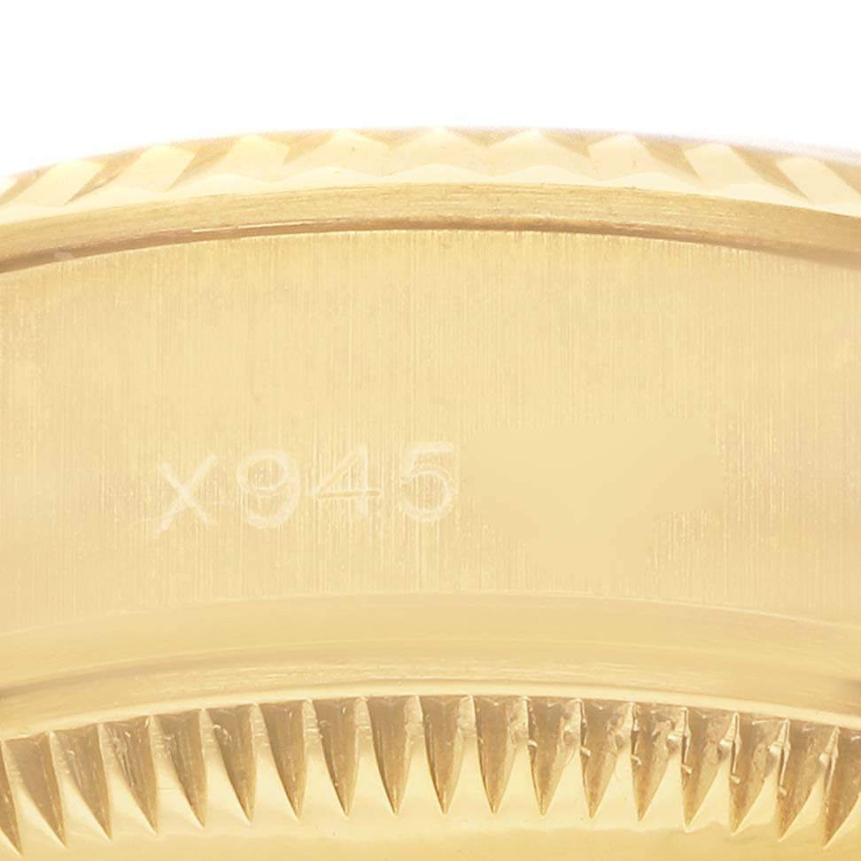 The image shows a close-up of the gold fluted bezel with engraving on a Rolex President 69178 Women's Yellow Gold Champagne Dial model watch.
