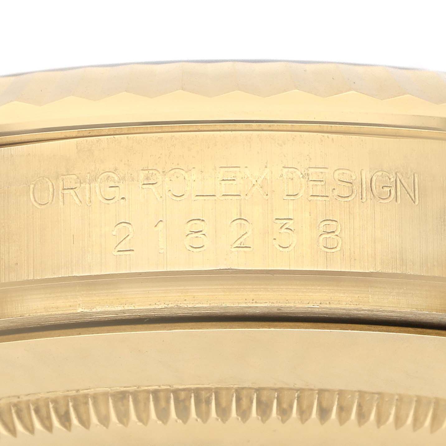 The image shows a close-up side view of the casing of the Rolex President 218238 Men's Yellow Gold Champagne Dial model, highlighting engraved details.