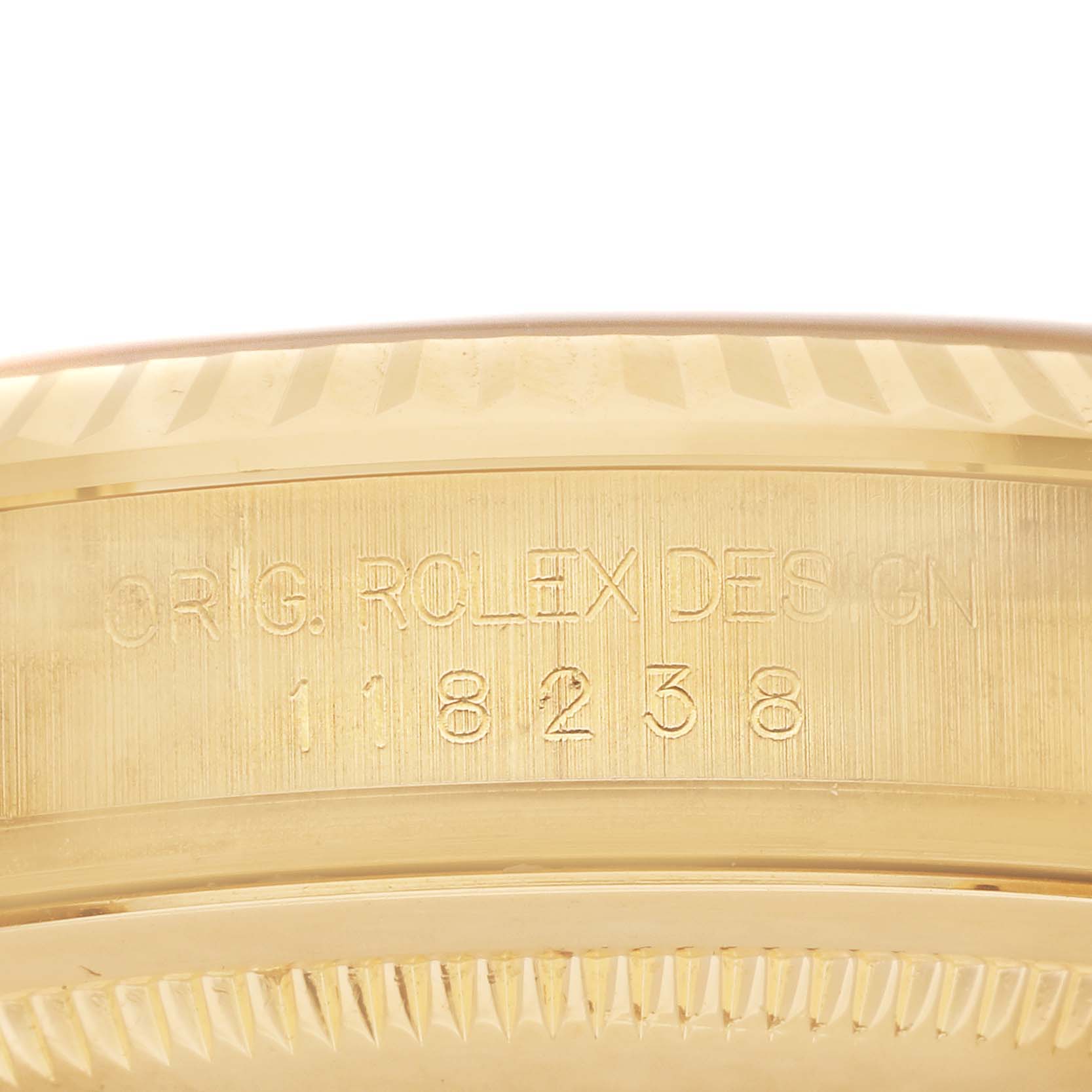 This image shows a close-up of the case side of a Rolex President 118238 Men's Yellow Gold Champagne Dial 118238 Men's Yellow Gold Champagne Dial model, revealing its engraved serial number.