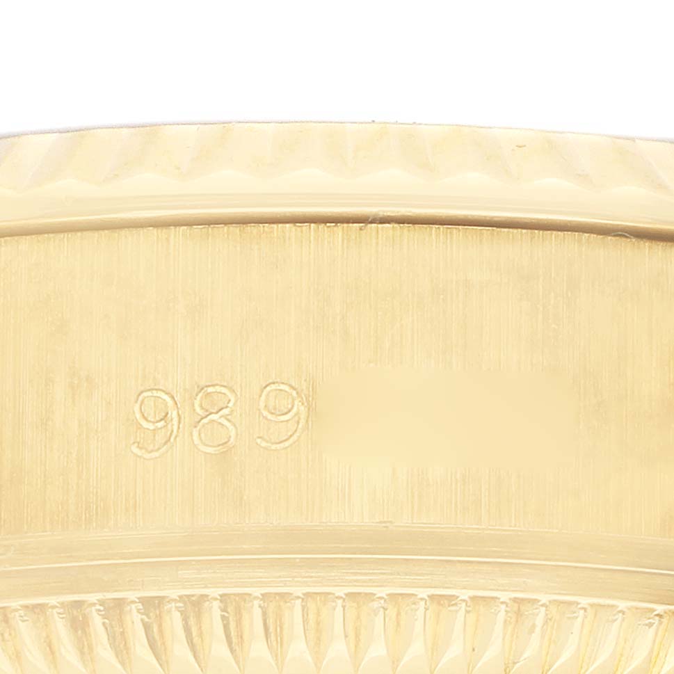 The image shows a close-up of the side of a Rolex President 69178 Women's Yellow Gold Champagne Dial watch, highlighting the bezel and part of the case with engraved numbers.