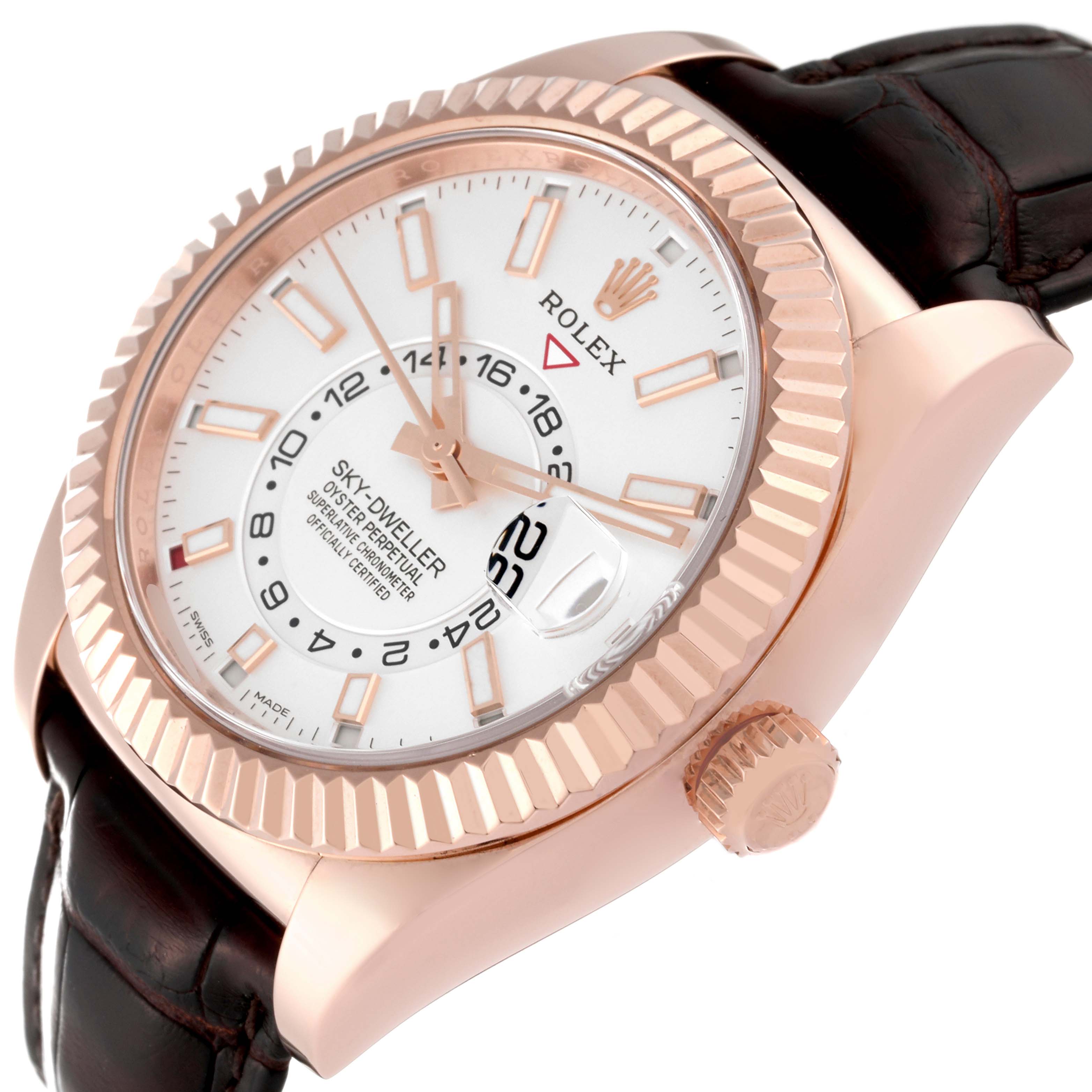 The Rolex Sky-Dweller 326135 Men's Rose Gold Silver Dial watch is angled to show the side, face, bezel, crown, and part of the leather strap.