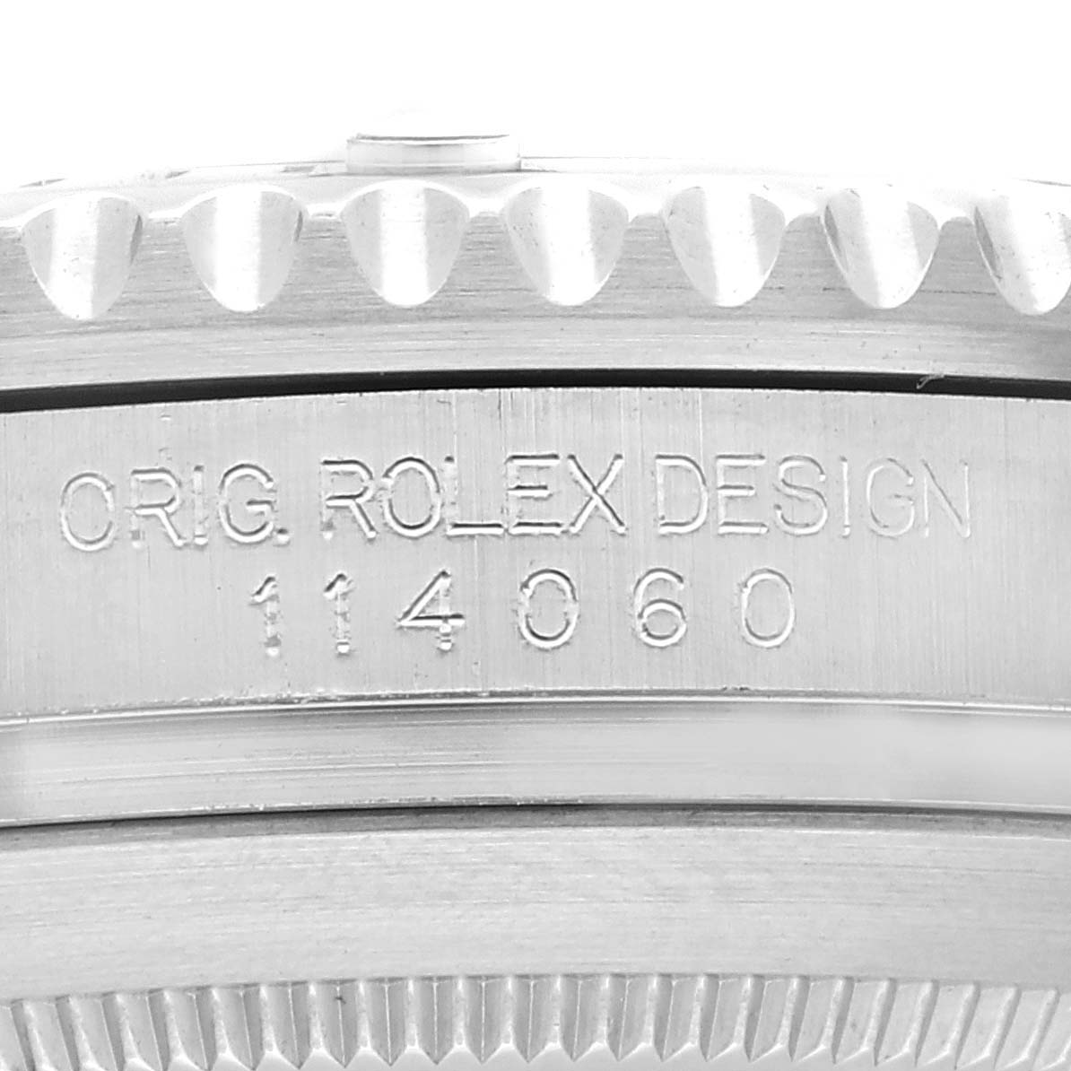 The image shows a close-up of the case side of a Rolex Submariner 114060 Men
s Stainless Steel Black Dial 114060 Men
s Stainless Steel Black Dial, highlighting the "ORIG. ROLEX DESIGN 114060" engraving.