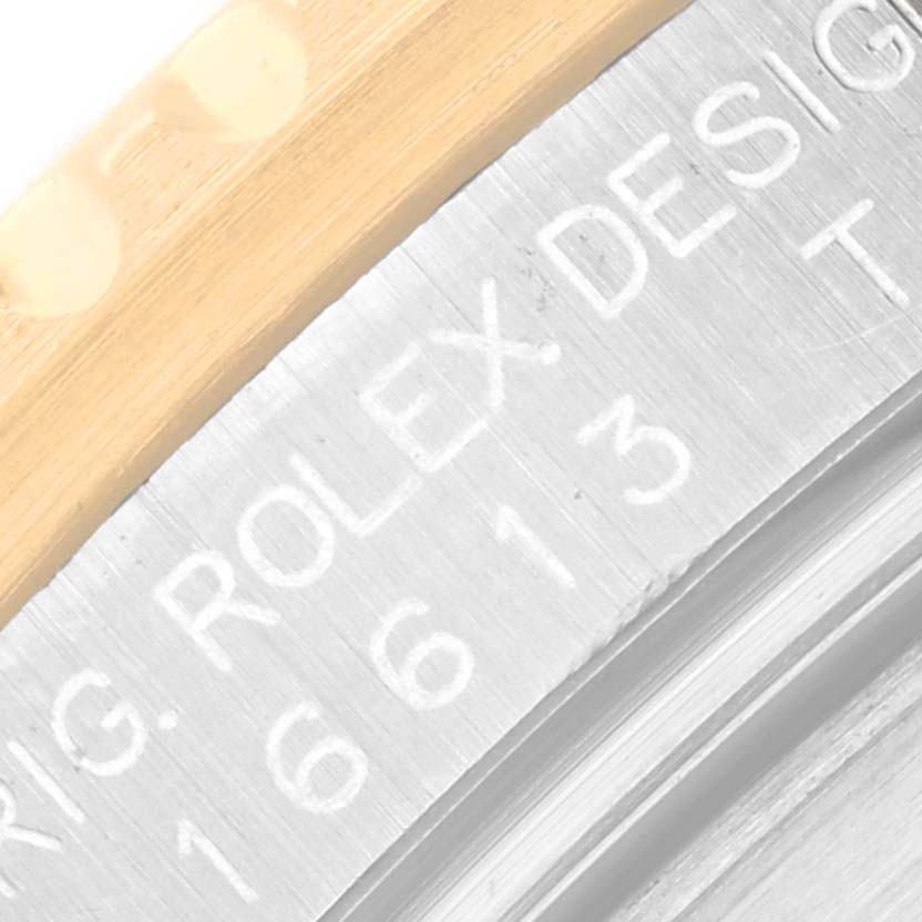 This close-up image of the Rolex Submariner 16613 Men's Steel and Gold (two tone) Blue Dial 16613 Men's Steel and Gold (two tone) Blue Dial model shows the engraved case back and part of the gold and steel bracelet.