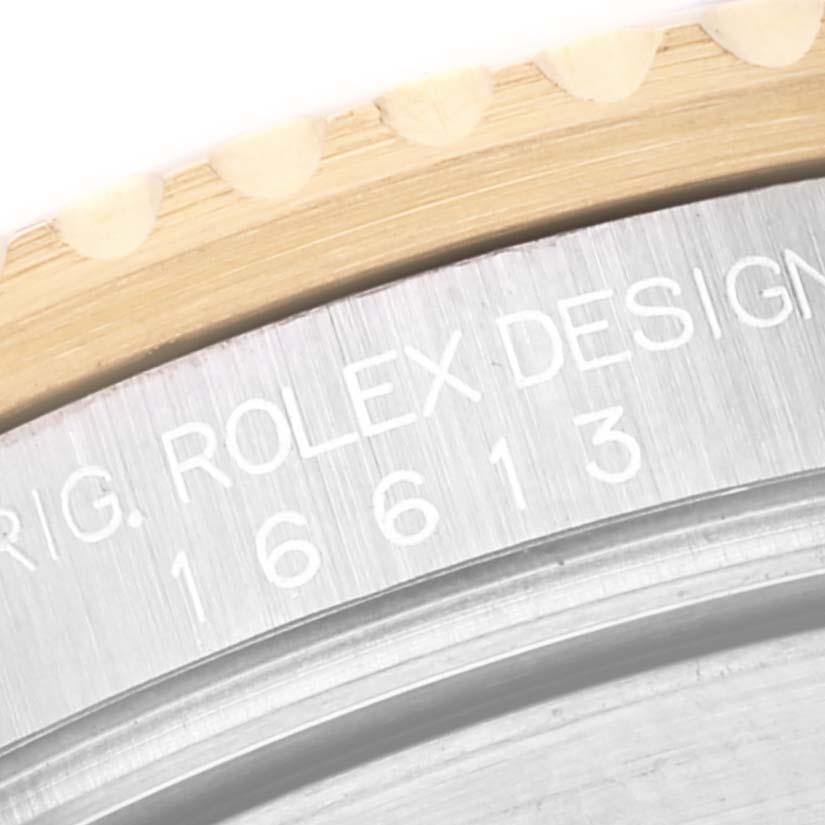 This close-up image shows the engraved text and part of the rotating bezel of a Rolex Submariner 16613 Men's Steel and Gold (two tone) Blue Dial 16613 Men's Steel and Gold (two tone) Blue Dial watch.