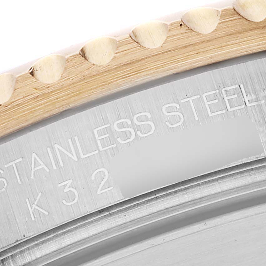 This close-up image shows the engraved stainless steel back and gold ridged edge of a Rolex Submariner 16613 Men's Steel and Gold (two tone) Blue Dial 16613 Men's Steel and Gold (two tone) Blue Dial model.