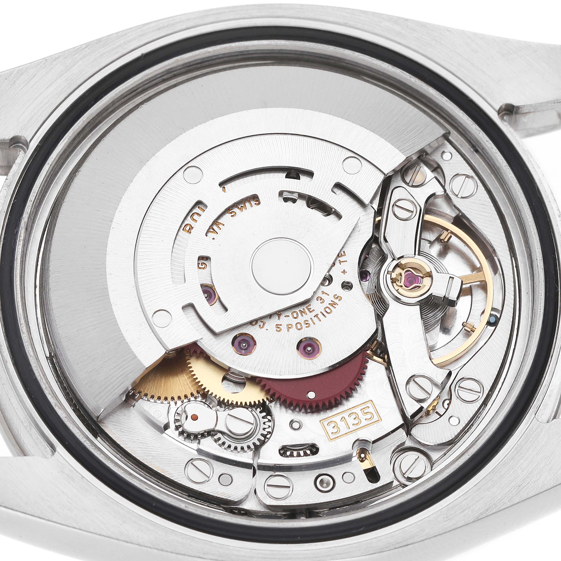 The image shows the internal movement of a Rolex Turn-o-Graph 116264 Men's Stainless Steel Black Dial watch, viewed from the back, revealing gears and components.