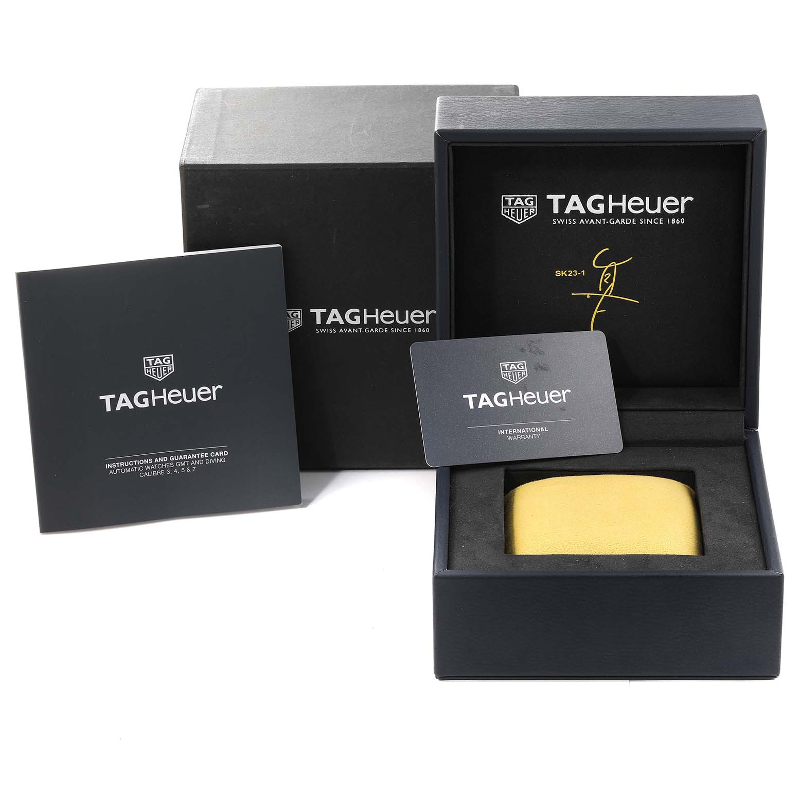 The image shows the packaging, international warranty card, and manual for a Tag Heuer Aquaracer watch.