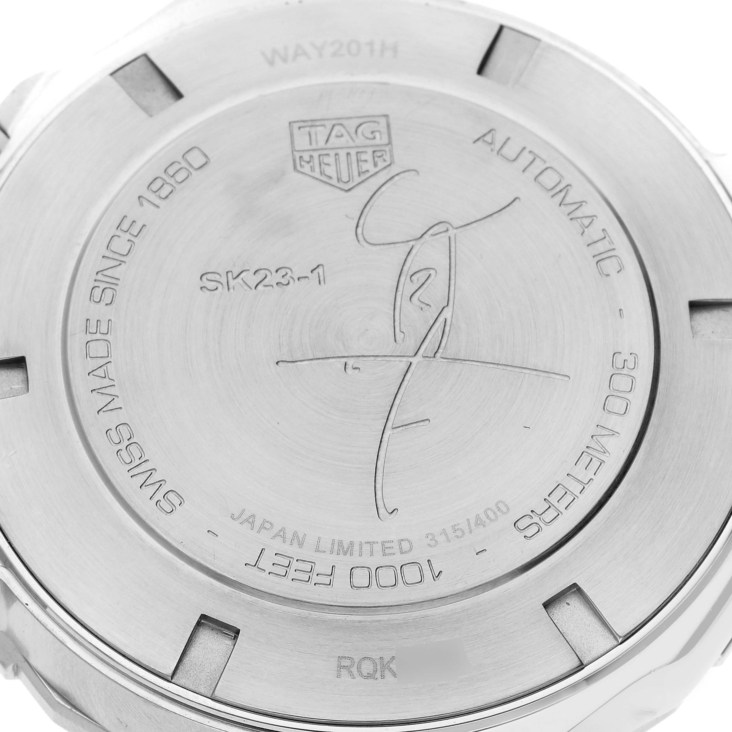 The image shows the back case of a Tag Heuer Aquaracer watch, featuring engravings and model information.