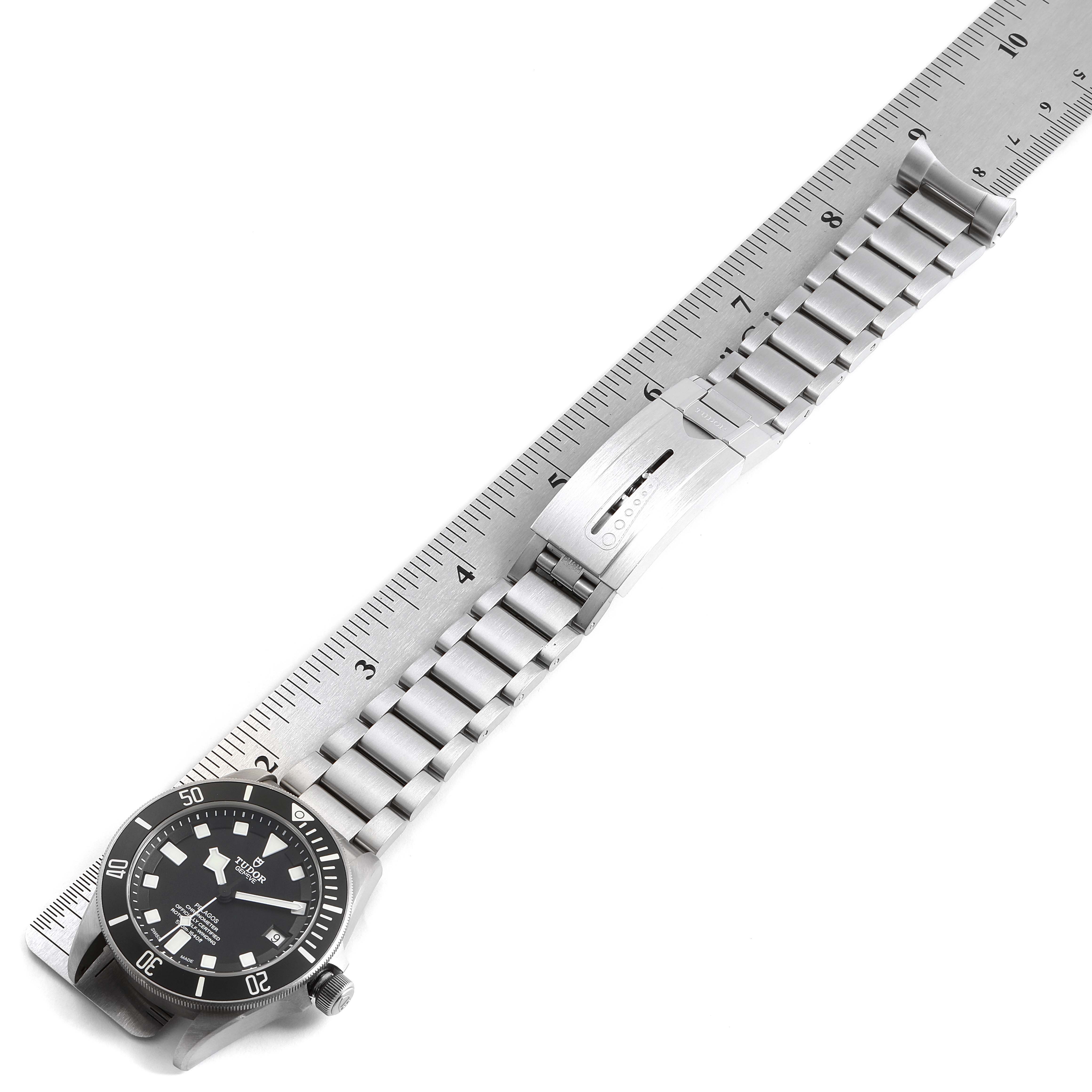 The image shows a Tudor Pelagos 25500TN Men's Titanium Black Dial 25500TN Men's Titanium Black Dial watch with a metal bracelet, clasp, and part of the bezel, viewed from above, placed alongside a ruler.