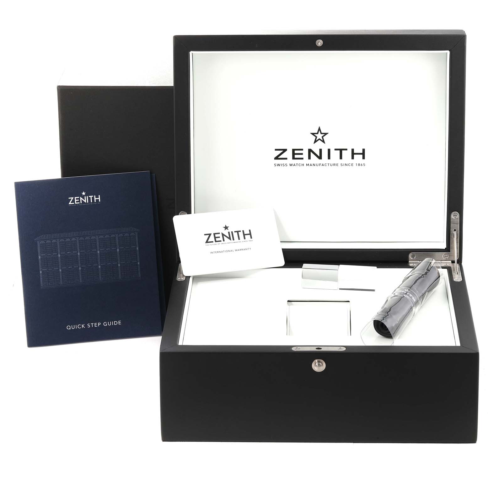 The image shows an open Zenith Chronomaster 03.3100.3600/21.M3100 Men's Stainless Steel Black Dial 03.3100.3600/21.M3100 Men's Stainless Steel Black Dial watch box with accessories, including a booklet and a warranty card.