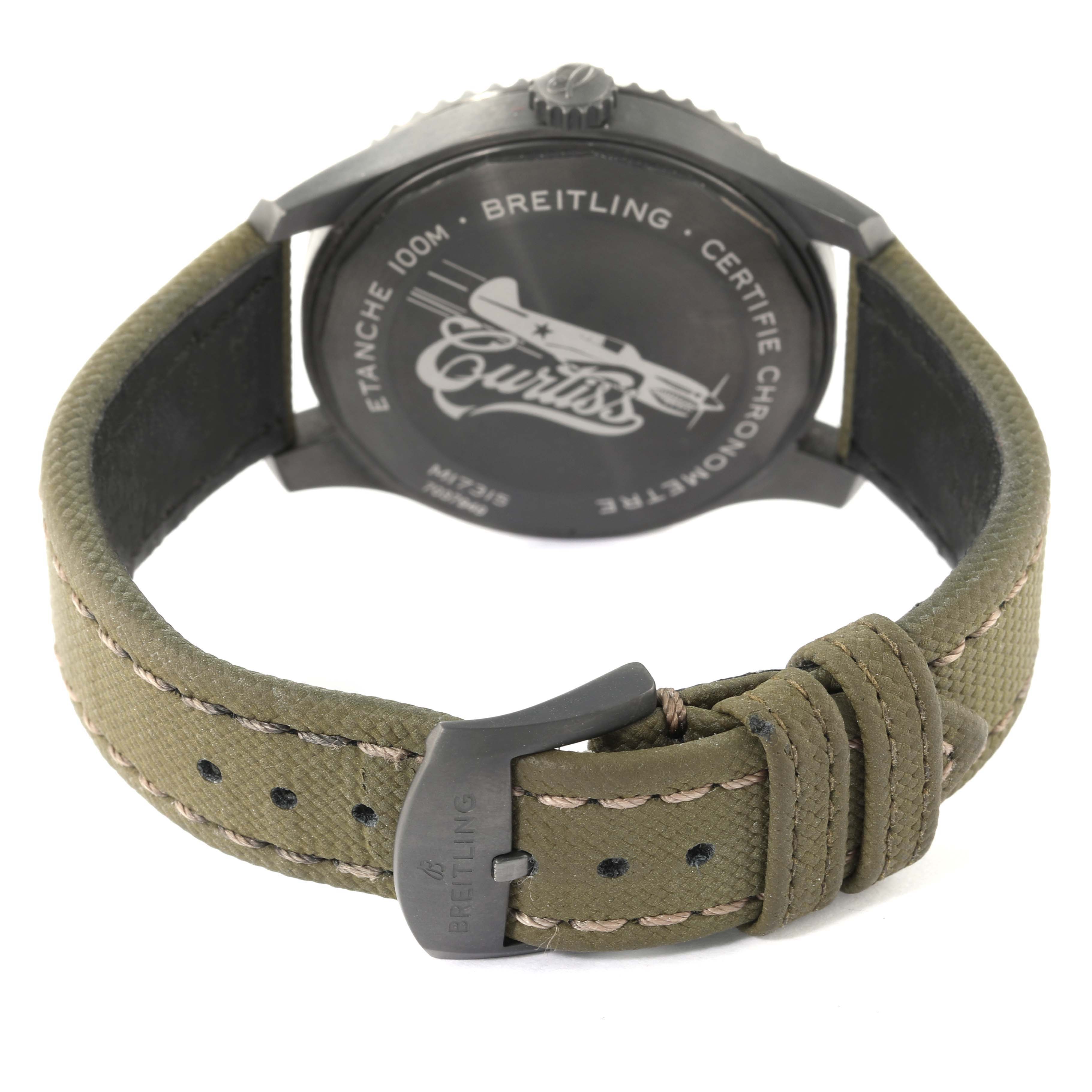 The image shows the Breitling Navitimer watch from the back, highlighting the case back and khaki green strap with buckle.