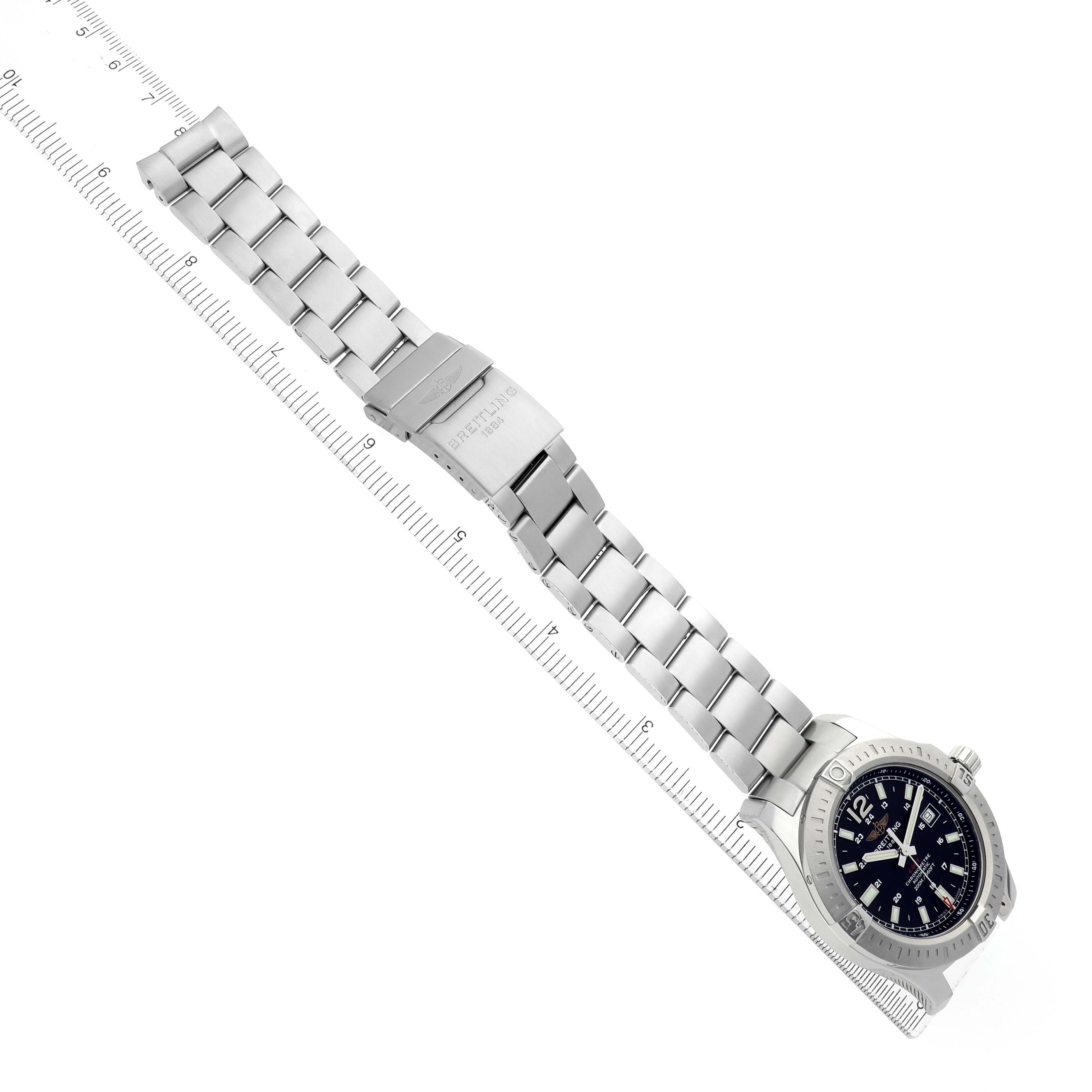 The Breitling Colt A17388 Men
s Stainless Steel Black Dial watch is displayed from above, showcasing the bracelet, clasp, and black dial on a ruler for scale.