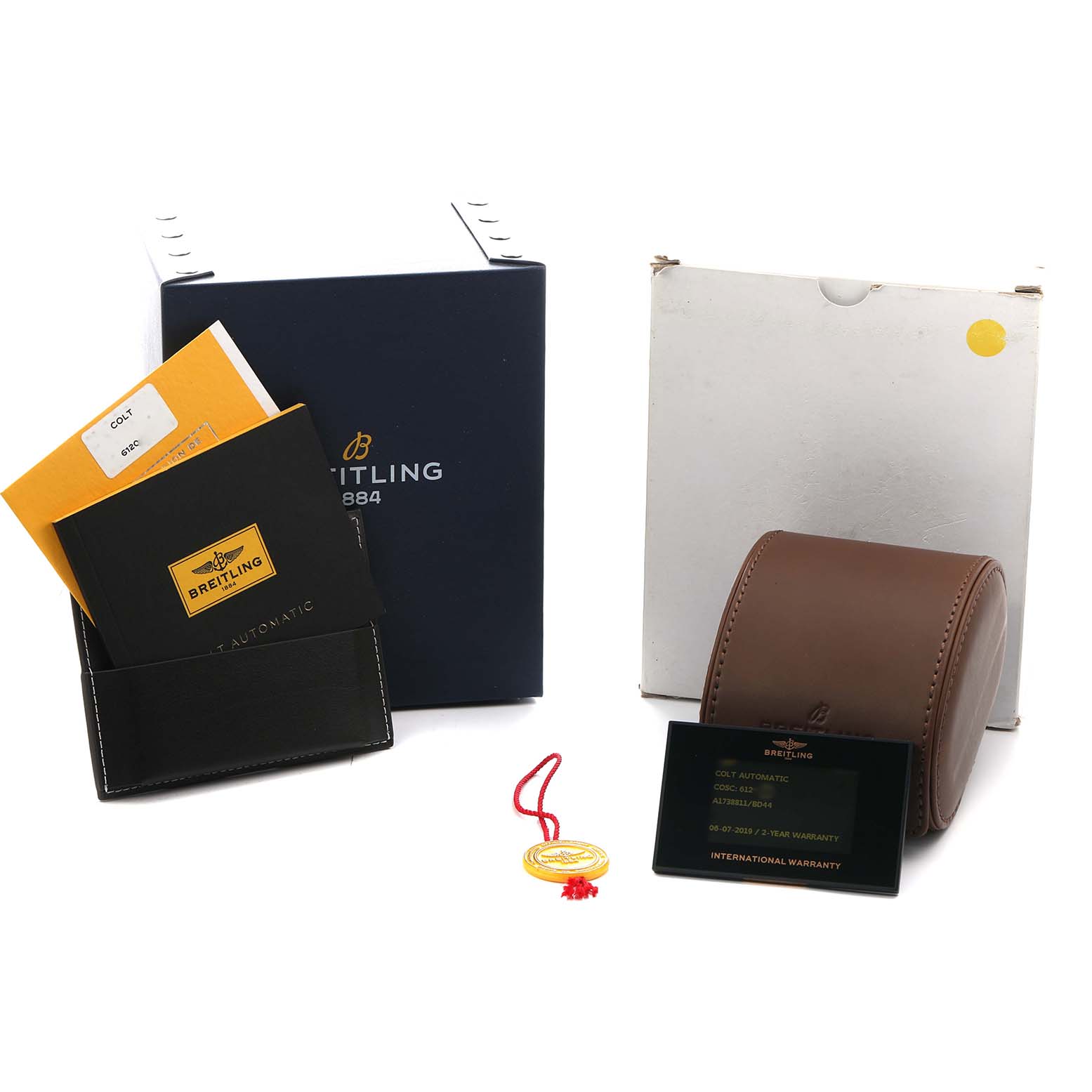 The image shows Breitling Colt A17388 Men
s Stainless Steel Black Dial accessories, including a box, manuals, a leather case, a warranty card, and a tag, viewed from the front.