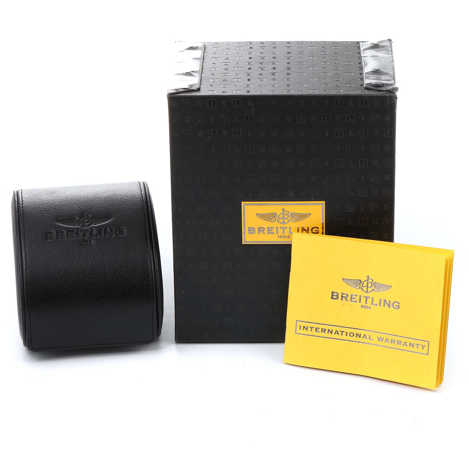 The image shows the packaging, black leather case, and international warranty booklet for the Colt model by Breitling.