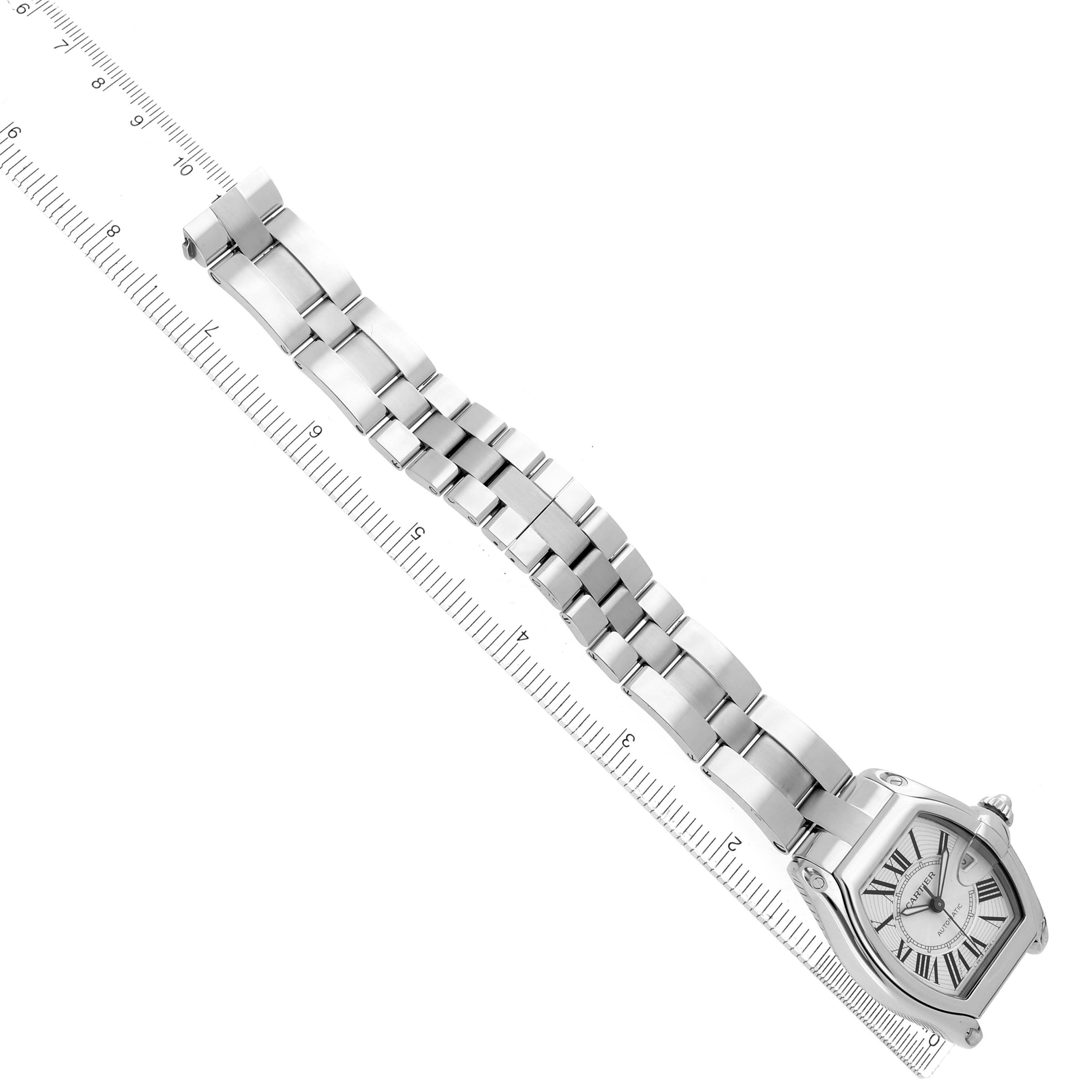 The Cartier Roadster W62025V3 Men
s Stainless Steel Silver Dial watch is shown from an angled top view, displaying the face and full bracelet next to a ruler for scale.