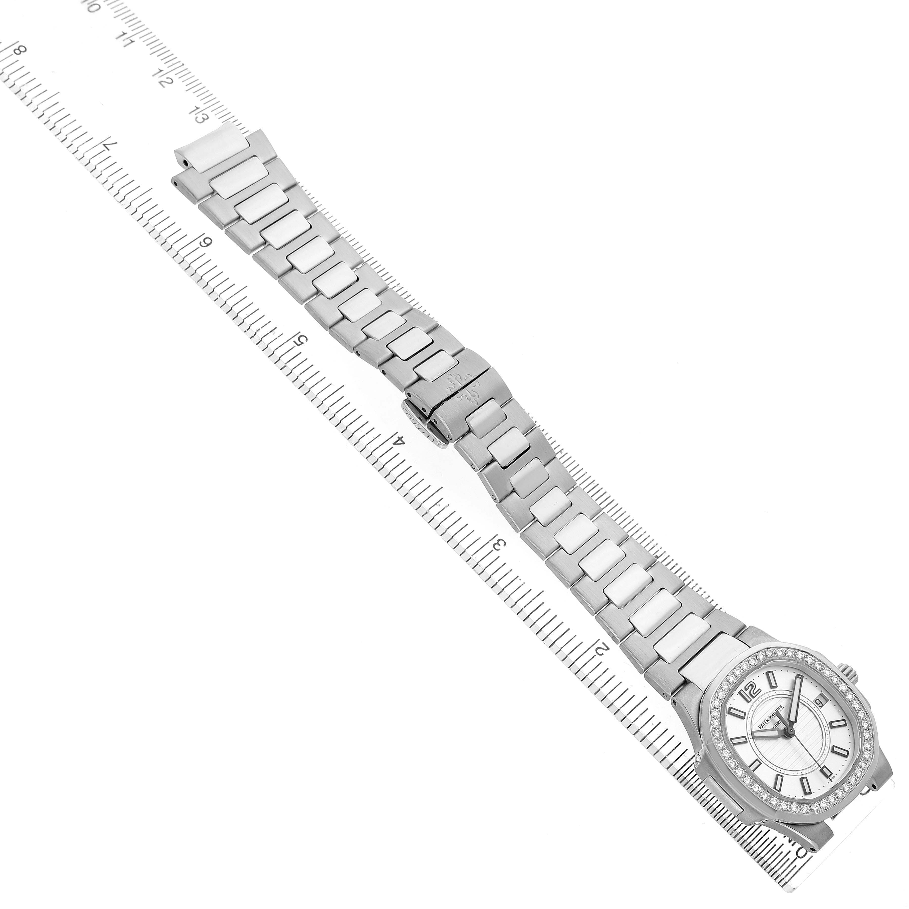 The image shows the Patek Philippe Nautilus 7010/1G-001 Women's White Gold Silver Dial watch from a top view, highlighting its bracelet, clasp, and face alongside a ruler for scale.
