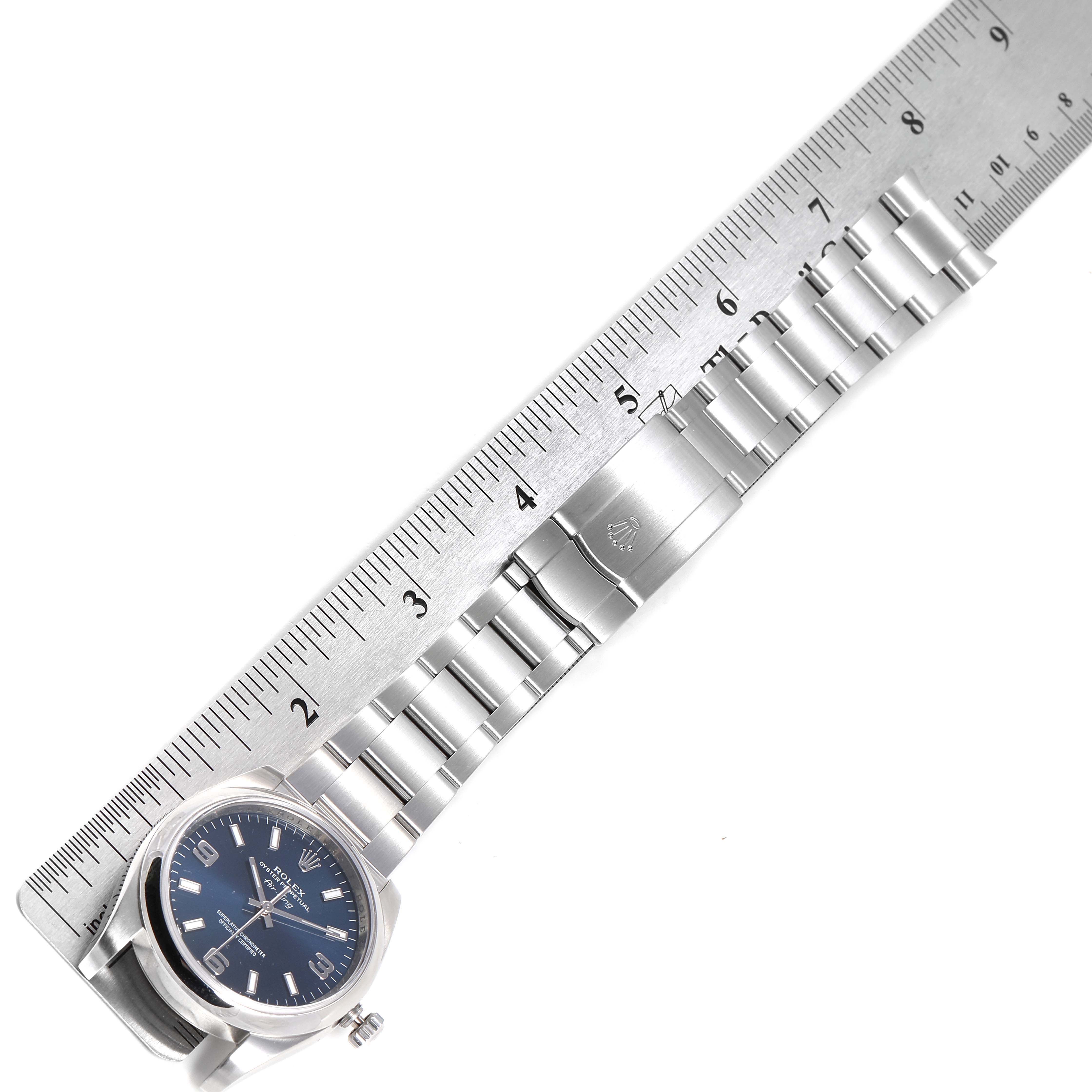 The image shows a side angle of a Rolex Air-King 114200 Men's Stainless Steel Blue Dial 114200 Men's Stainless Steel Blue Dial watch, focusing on its clasp and bracelet with a ruler for scale.
