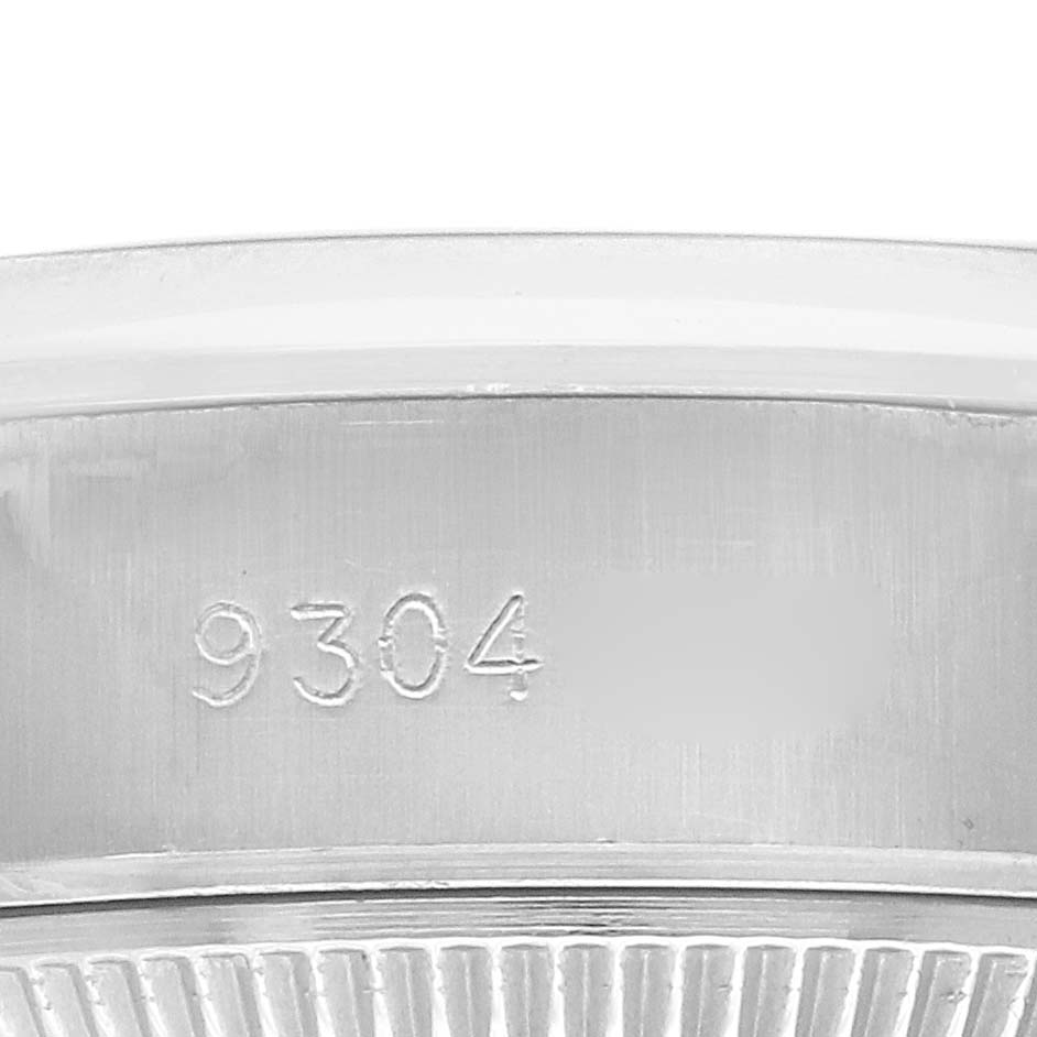 The image shows a close-up of the serial number and fluted bezel of a Rolex Date 69160 Women
s Stainless Steel White Dial model watch.