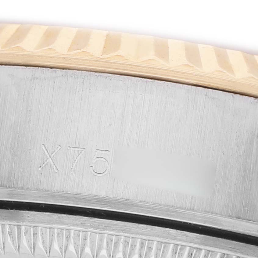 The image shows a close-up of the fluted bezel and engraved side of a Rolex Datejust 69173 Women's Steel and Gold (two tone) Champagne Dial watch.