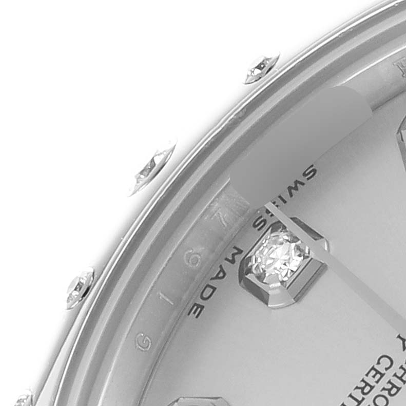 The image shows a close-up of the dial and bezel of a mid-size Rolex watch, highlighting the hour markers and part of the watch face.