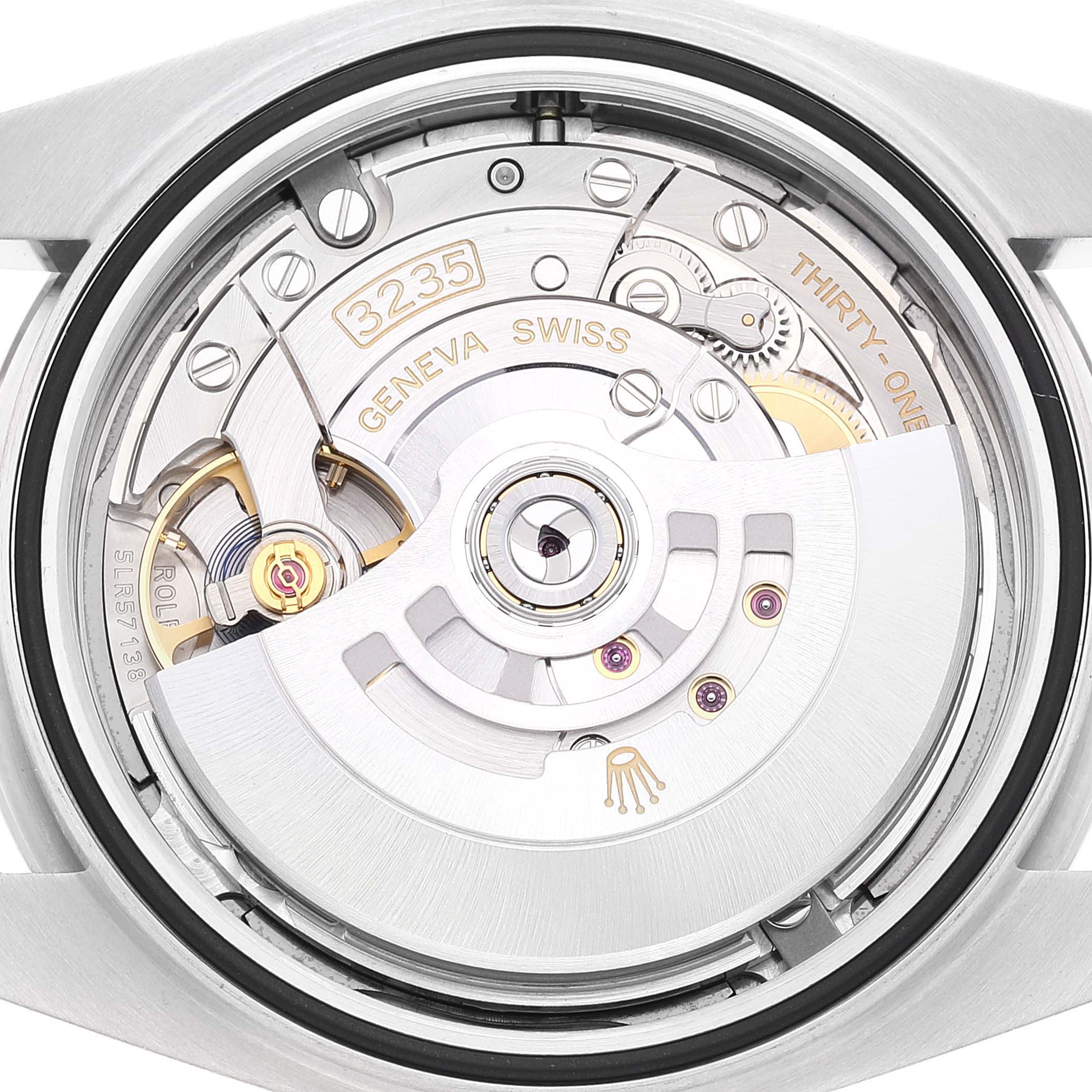 The image shows the movement mechanism of a Rolex Datejust 41 126300 Men's Stainless Steel Blue Dial 126300 Men's Stainless Steel Blue Dial, viewed from the back, highlighting gears and engravings.