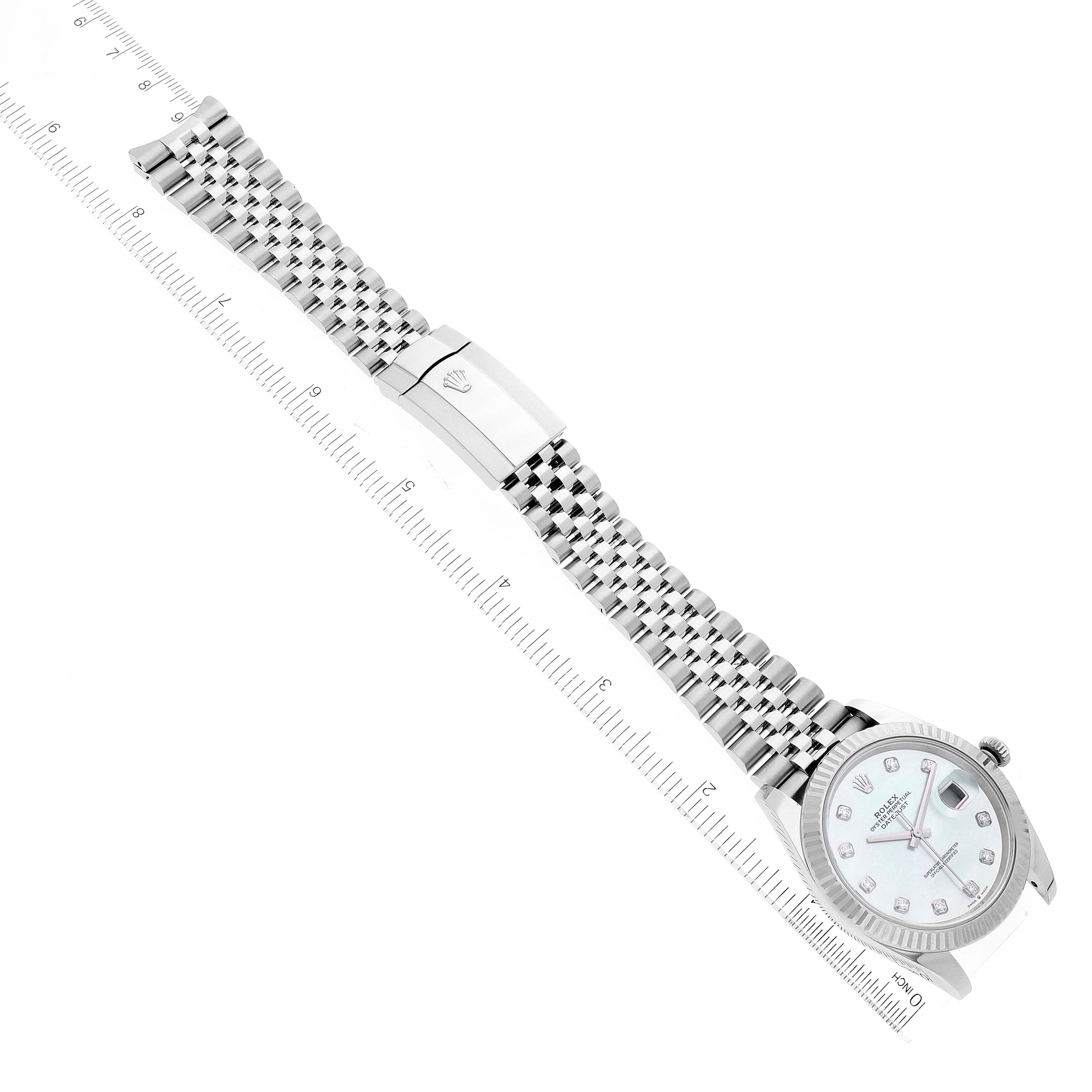 The image shows a top-down view of the Rolex Datejust 41 126334 Men
s Stainless Steel Mother of Pearl Dial 126334 Men
s Stainless Steel Mother of Pearl Dial watch, featuring the full bracelet extended next to a ruler for scale.