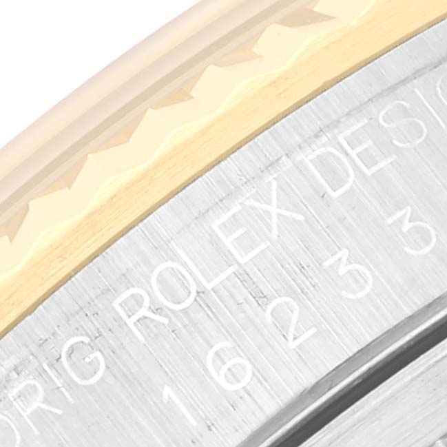 This close-up image shows the side of a Rolex Datejust 16233 Men's Steel and Gold (two tone) Champagne Dial 16233 Men's Steel and Gold (two tone) Champagne Dial, highlighting the fluted bezel, and part of the engraved text.