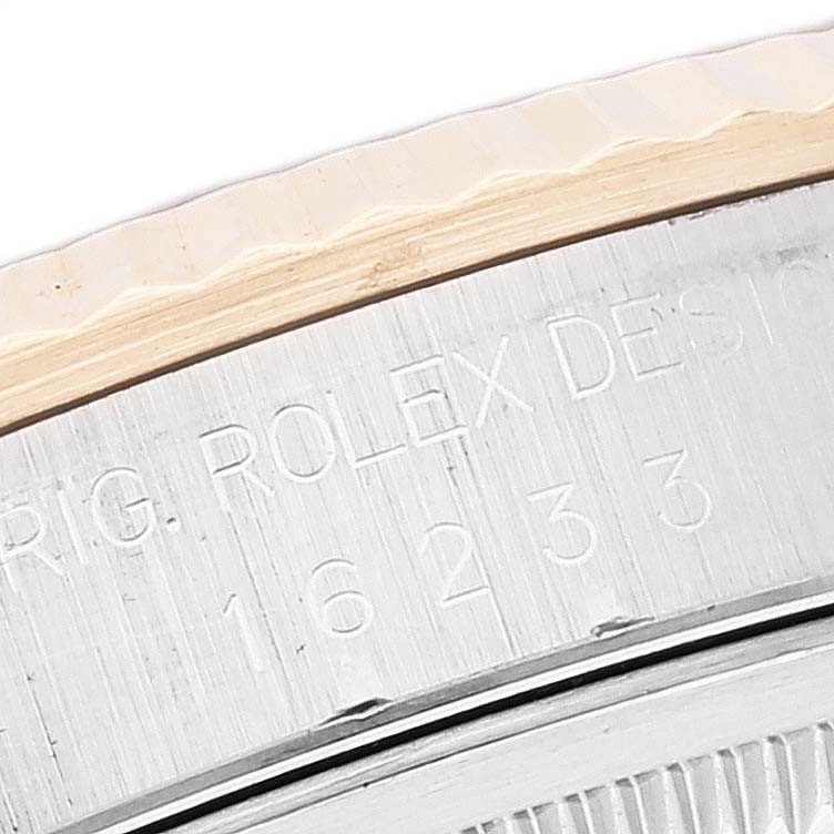 This close-up image of a Rolex Datejust 16233 Men's Steel and Gold (two tone) Blue Dial 16233 Men's Steel and Gold (two tone) Blue Dial watch shows the engraved model and brand name on the case side and part of the fluted bezel.