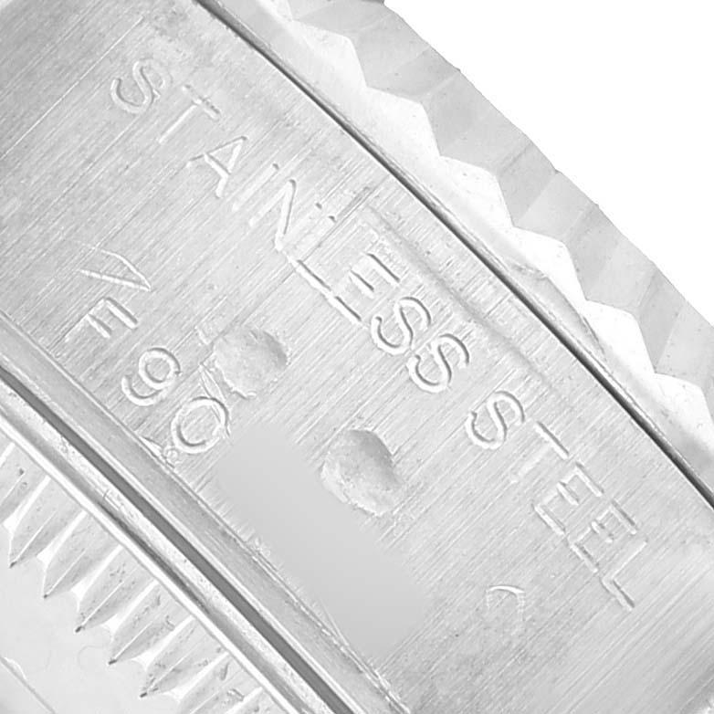 The image shows a close-up of a stainless steel case with engraved text on a Rolex Datejust 79174 Women's Stainless Steel Blue Dial watch.
