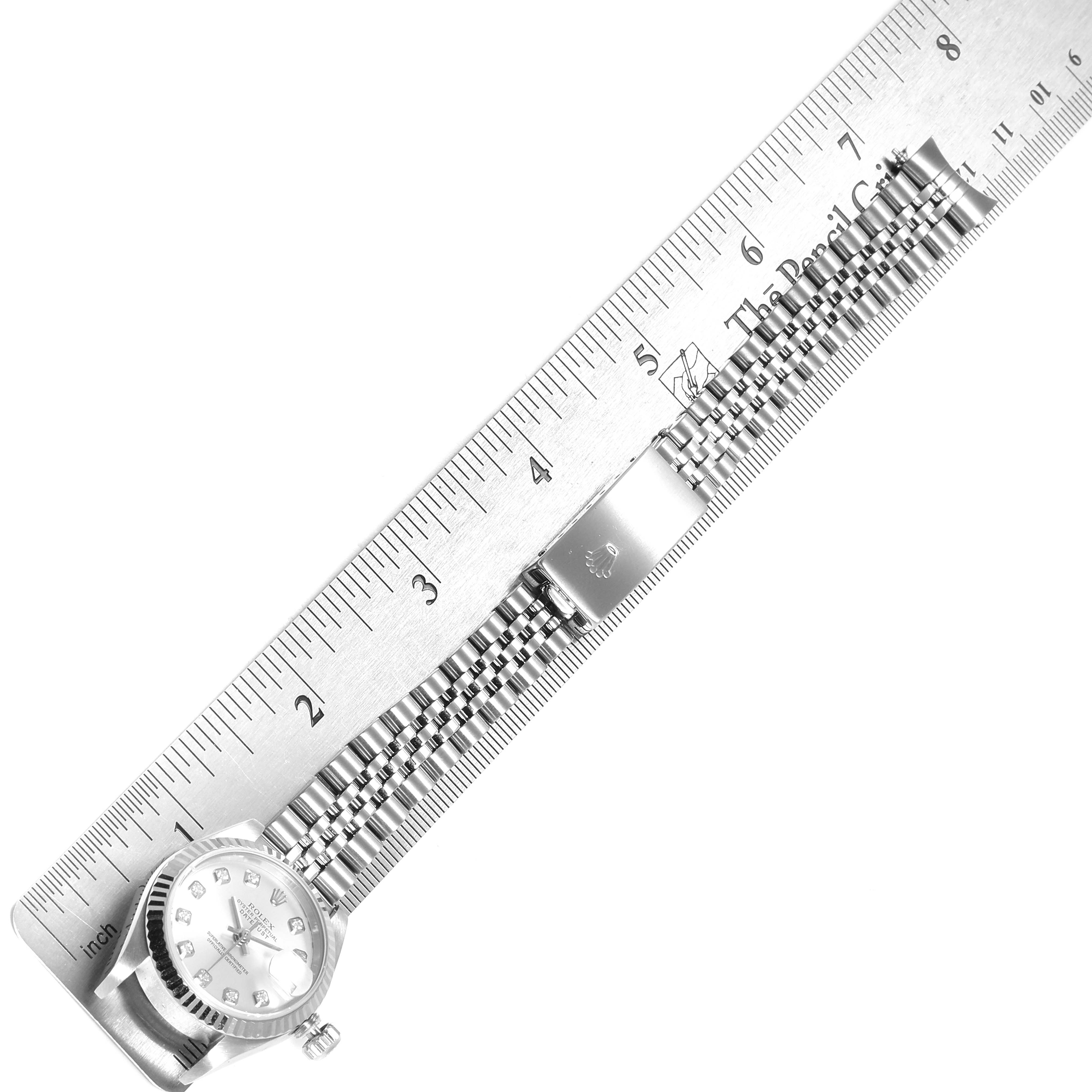 The Rolex Datejust 79174 Women
s Stainless Steel Silver Dial 79174 Women
s Stainless Steel Silver Dial model is shown from a top-down angle, displaying the watch face, bezel, and bracelet against a ruler.