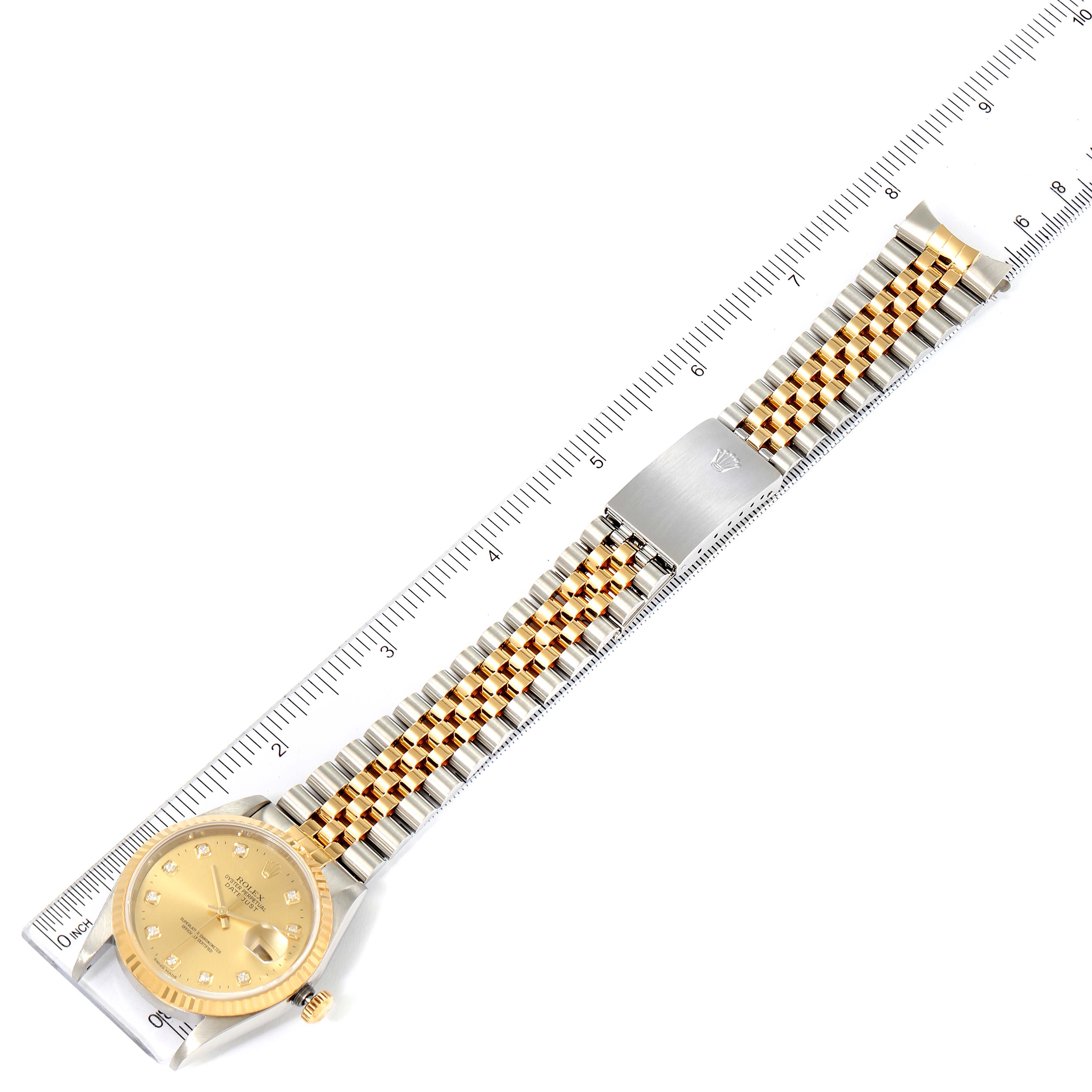 The image shows the Rolex Datejust 16233 Men's Steel and Gold (two tone) Champagne Dial 16233 Men's Steel and Gold (two tone) Champagne Dial watch from a top view, displaying the entire watch face and bracelet with a measuring ruler for scale.
