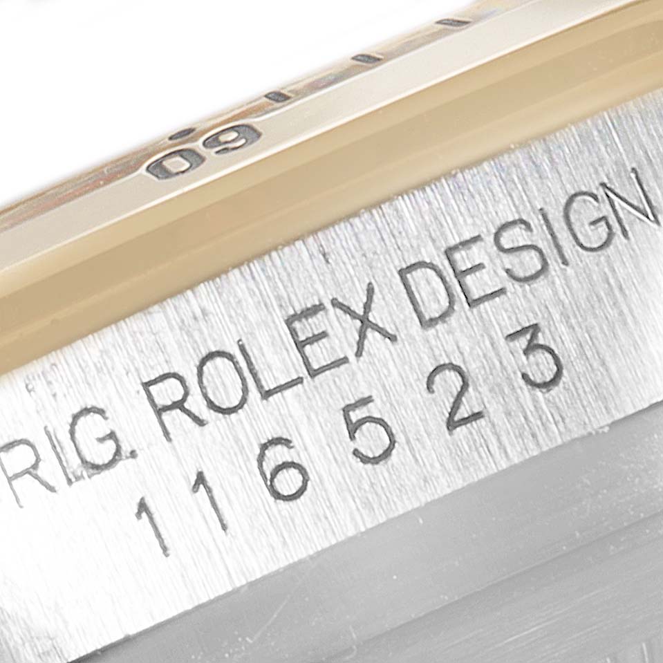 This close-up image shows the side view of a Rolex Daytona 116523 Men's Steel and Gold (two tone) Mother of Pearl Dial 116523 Men's Steel and Gold (two tone) Mother of Pearl Dial model with the bezel and engraved model number.