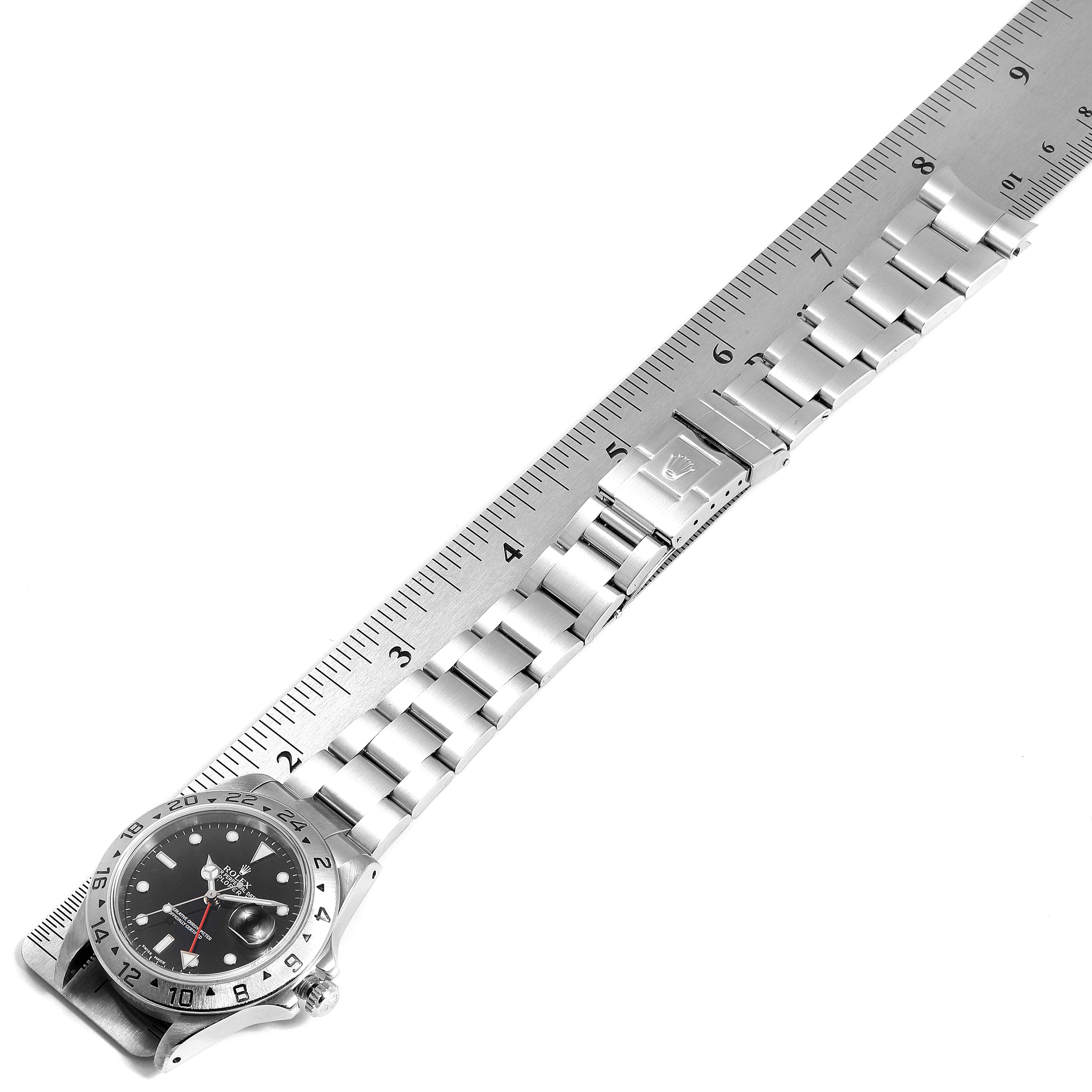 This image shows a Rolex Explorer 16570 Men
s Stainless Steel Black Dial 16570 Men
s Stainless Steel Black Dial model watch laid flat, highlighting its stainless steel bracelet and clasp, alongside a ruler for scale.