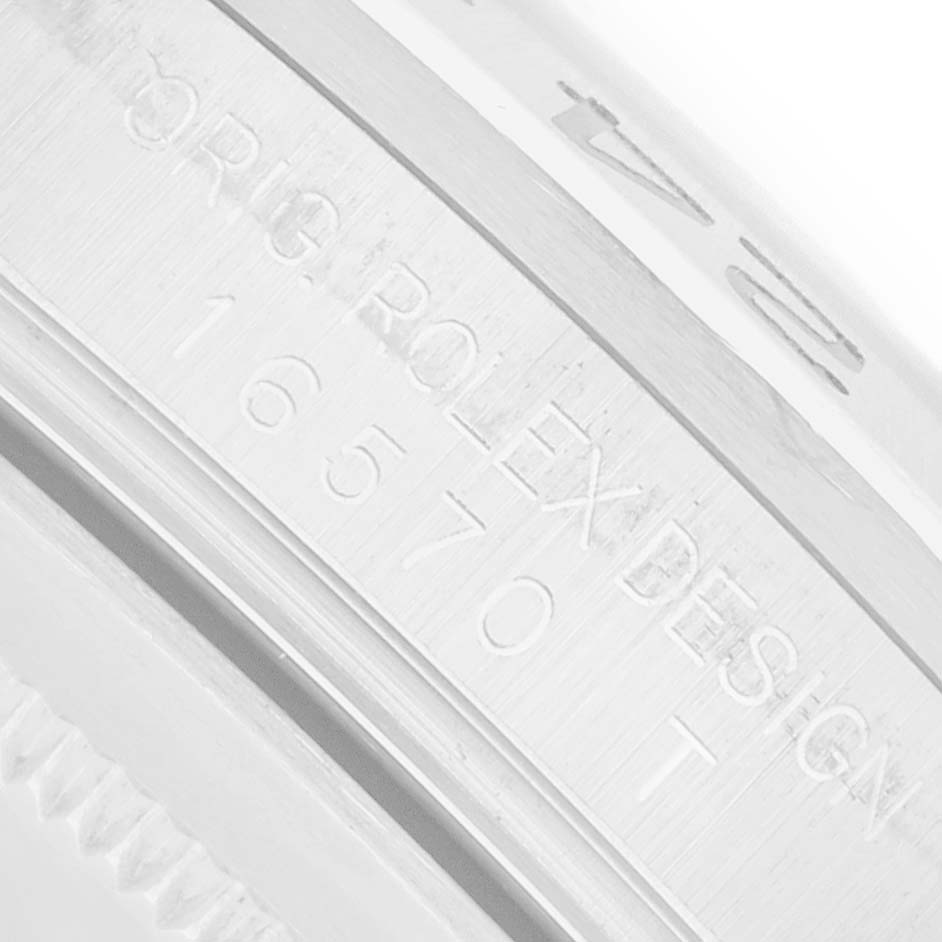 The image shows a close-up of the Rolex Explorer 16570 Men
s Stainless Steel White Dial model
s case engraving with a partial view of the bezel.