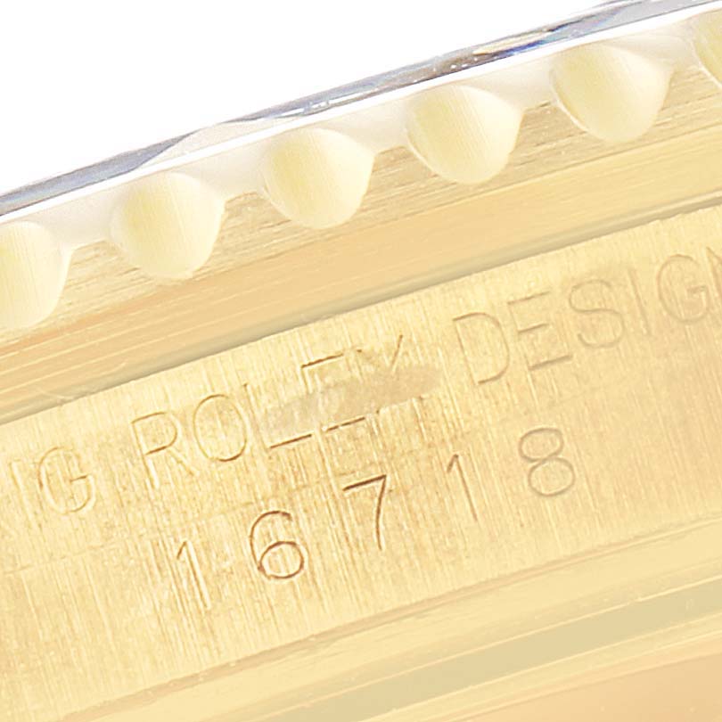 The image shows a close-up of the Rolex GMT-Master 16718 Men
s Yellow Gold Black Dial 16718 Men
s Yellow Gold Black Dial
s case side, highlighting the serial number engraving.