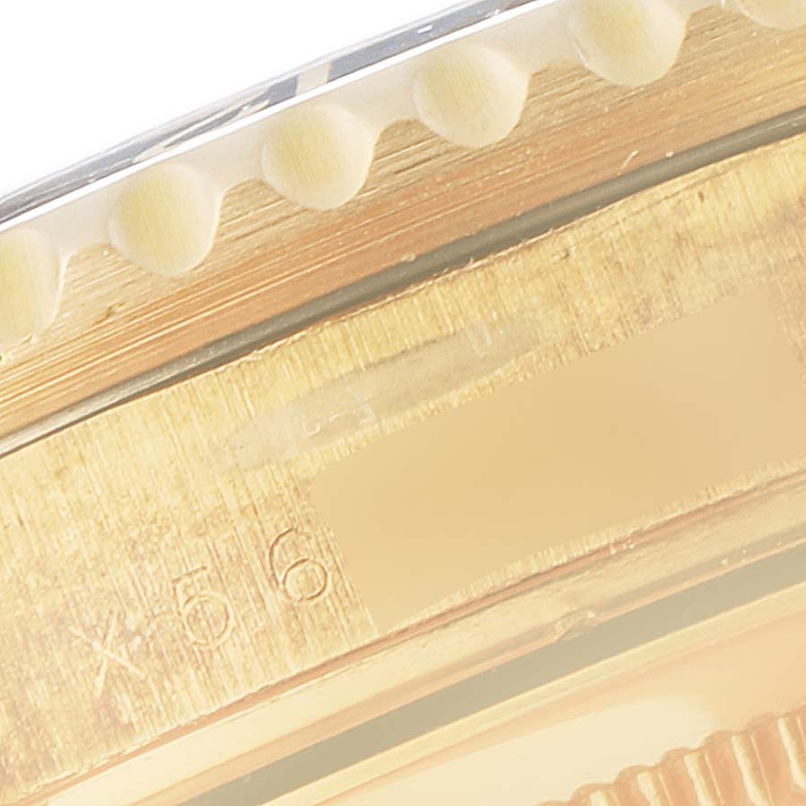 This image shows a close-up of the bezel and part of the lug area of a Rolex GMT-Master 16718 Men
s Yellow Gold Black Dial 16718 Men
s Yellow Gold Black Dial watch.